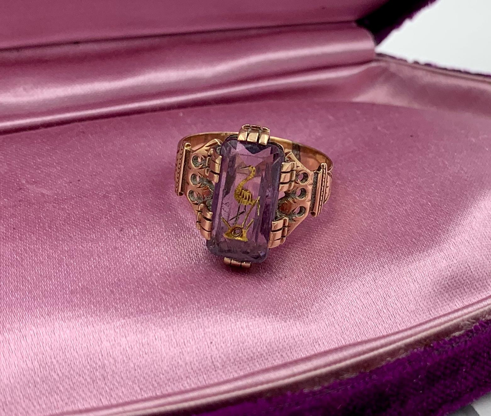 A stunning and rare antique Victorian inlaid intaglio Amethyst Ring with an image of a Stork or Bird in a spectacular crown motif setting in 14 Karat Gold.  The rectangular faceted Amethyst is carved with an image of a Stork.  The intaglio carving