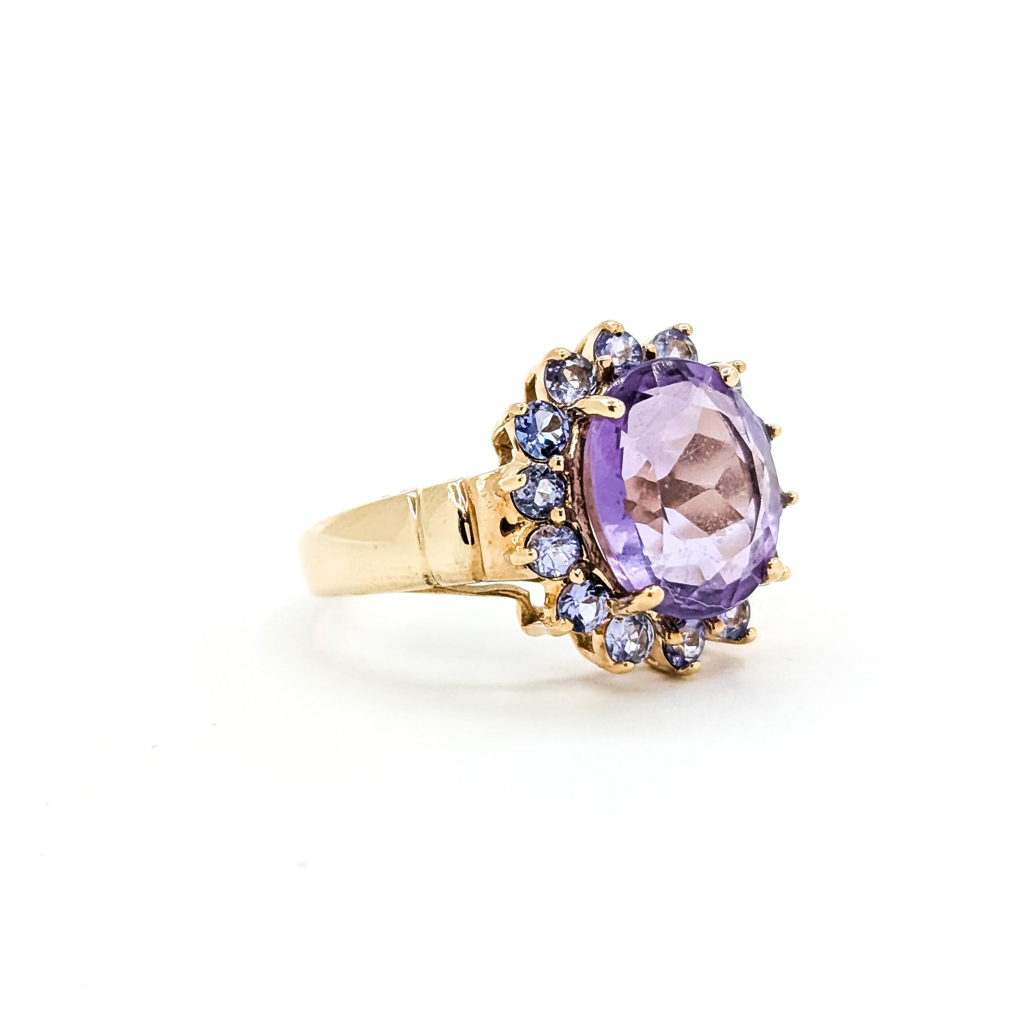 Bague cocktail en or jaune 10k avec améthyste et tanzanite

Cette bague en or jaune 10k est ornée d'une améthyste ovale de 3,88 carats montée sur griffes, encadrée d'un halo de tanzanites rondes totalisant 0,42 carats. L'association d'un violet