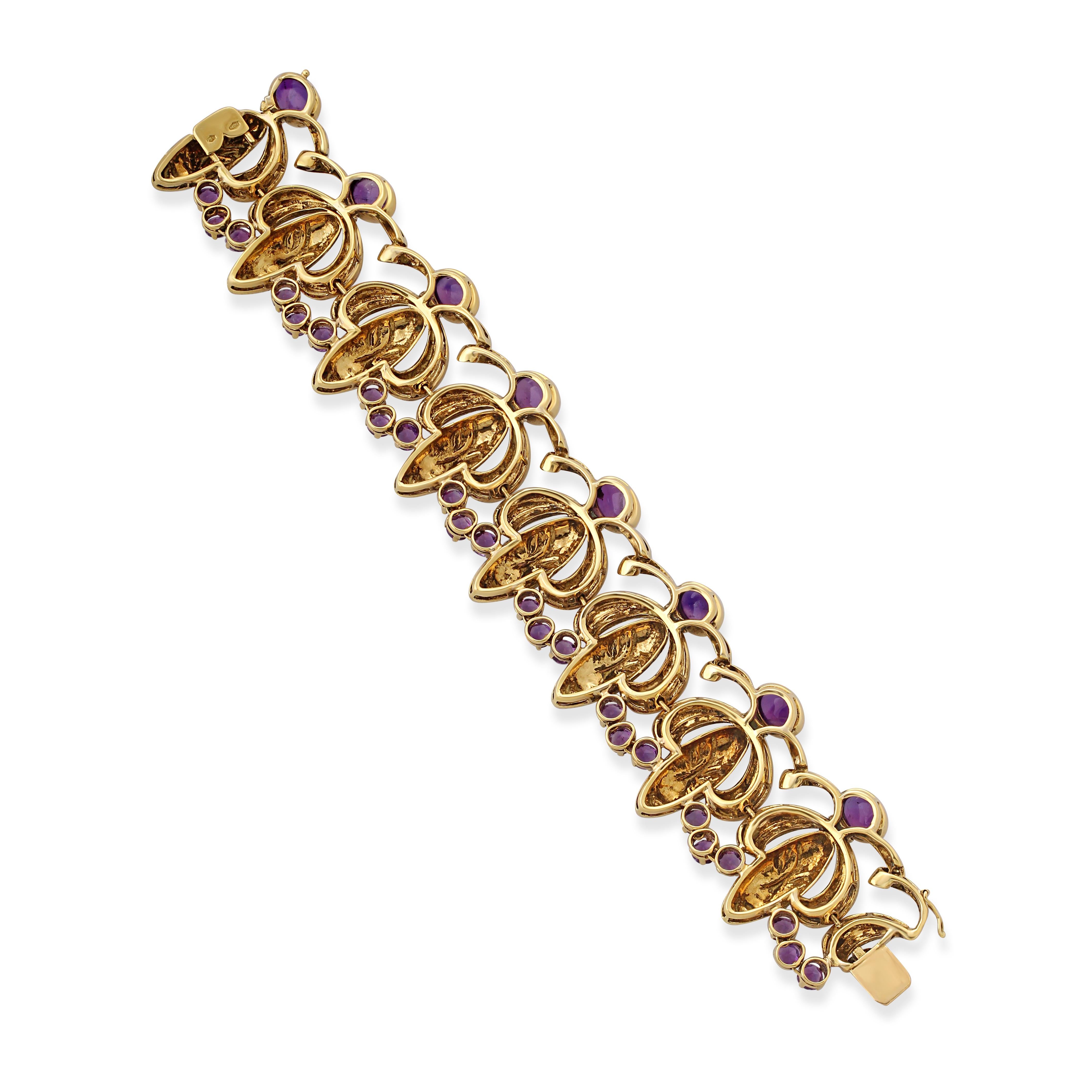 A uniquely designed gold and amethyst bracelet. Crafted in 18k hammered textured gold stylised as a repeating motif of smiling faces topped with cabochon amethysts and linked with three circle-cut amethysts. Circa 1960s. Approximately 15 carats
