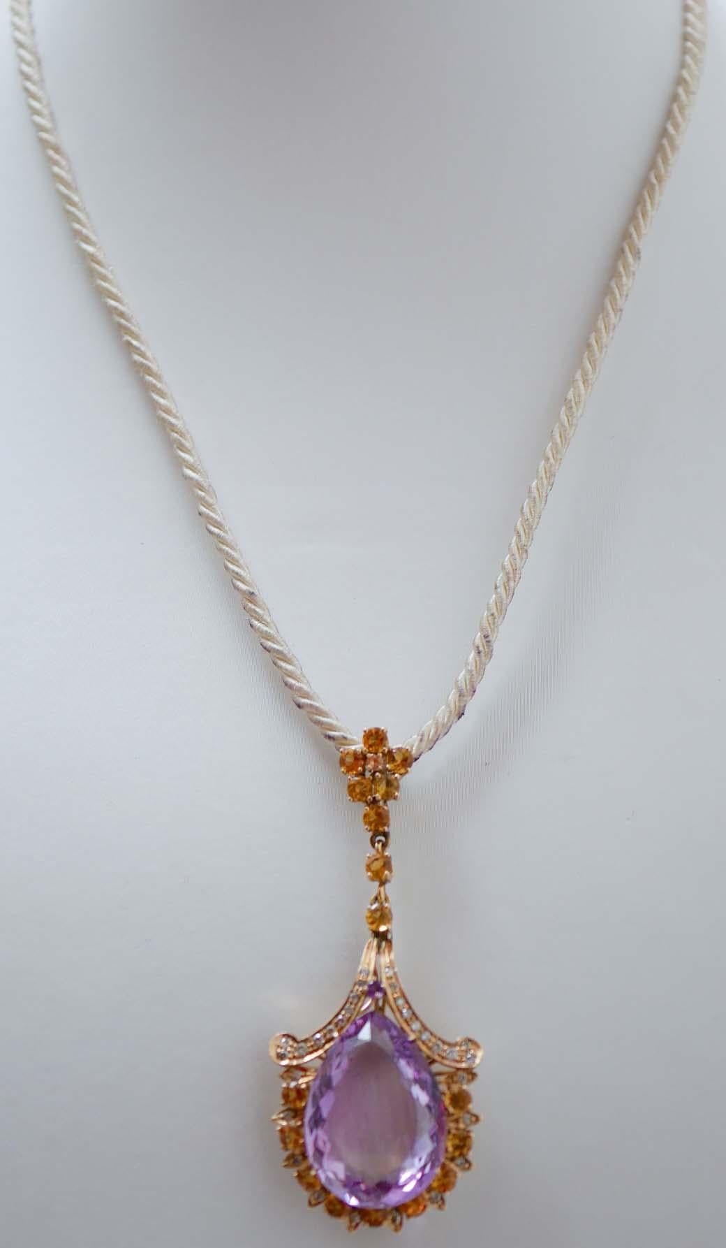 Superbe pendentif en or rose 14 carats monté d'une améthyste centrale entourée de diamants et de topazes . Dans la partie supérieure, une fleur de topazes. Le pendentif est livré avec une chaîne en caoutchouc.
Ce pendentif a été entièrement réalisé