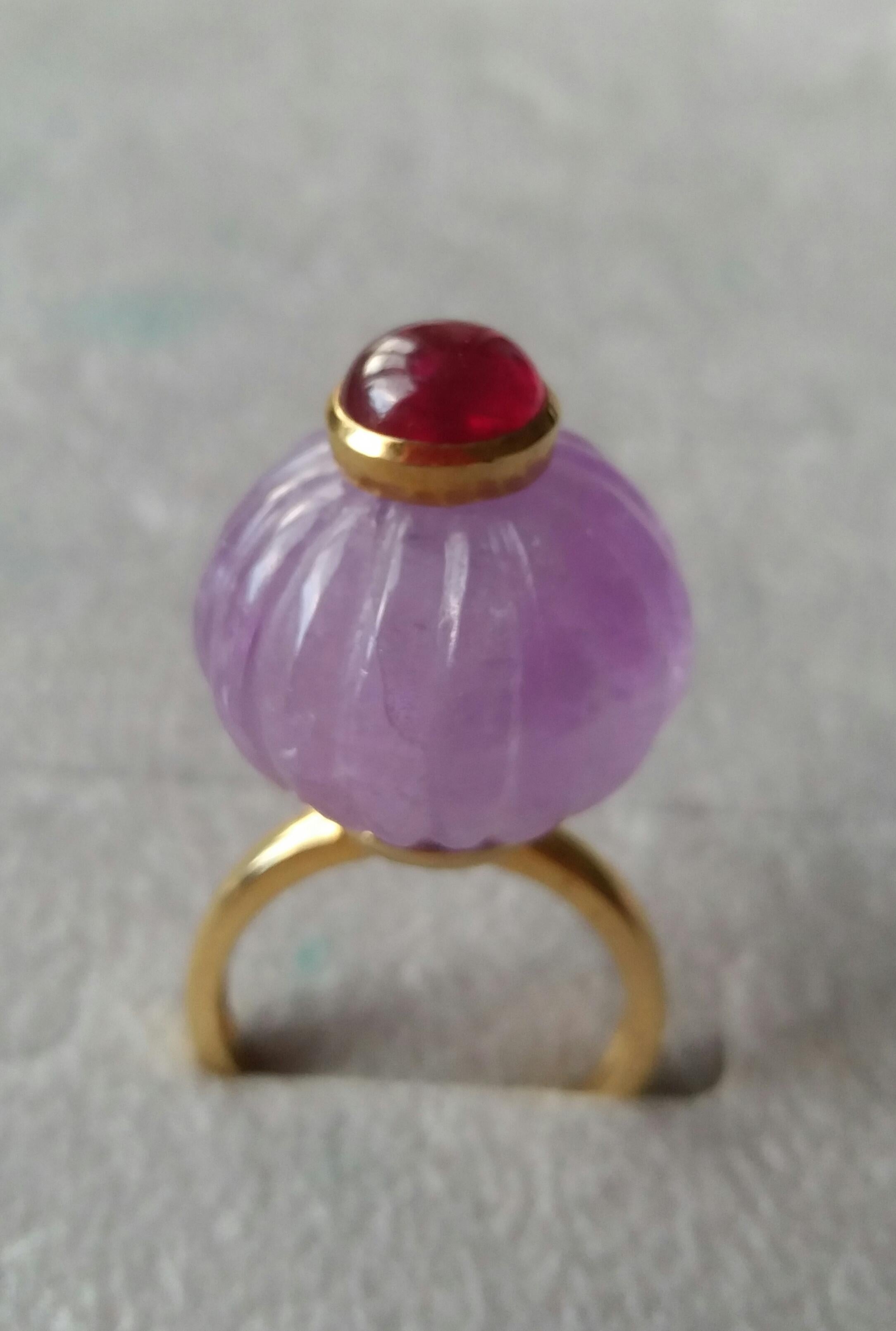 Melon cut Amethyst Round Bead  of 20 mm. in diameter and 16 mm. thick with a round Ruby cabochon of 8 mm. in diameter in the center is mounted on top of a 14 Kt. yellow gold shank.
In 1978 our workshop started in Italy to make simple-chic Art Deco