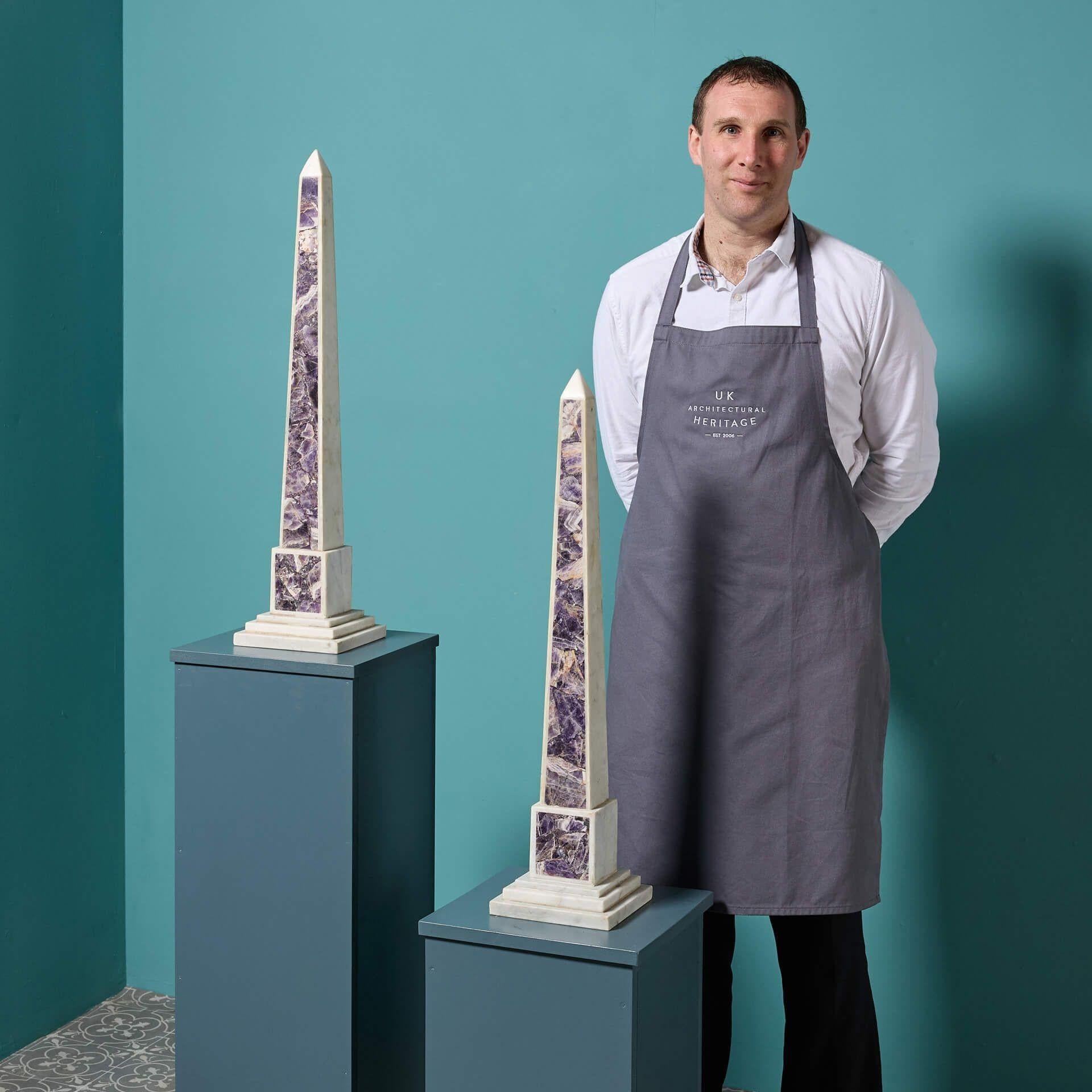 Una coppia di grandi obelischi in marmo statuario bianco e ametista recuperati. Questa coppia di obelischi abbinati in stile neoclassico è adatta a qualsiasi interno, moderno o d'epoca.

Risalenti alla metà del XX secolo, questi obelischi sono