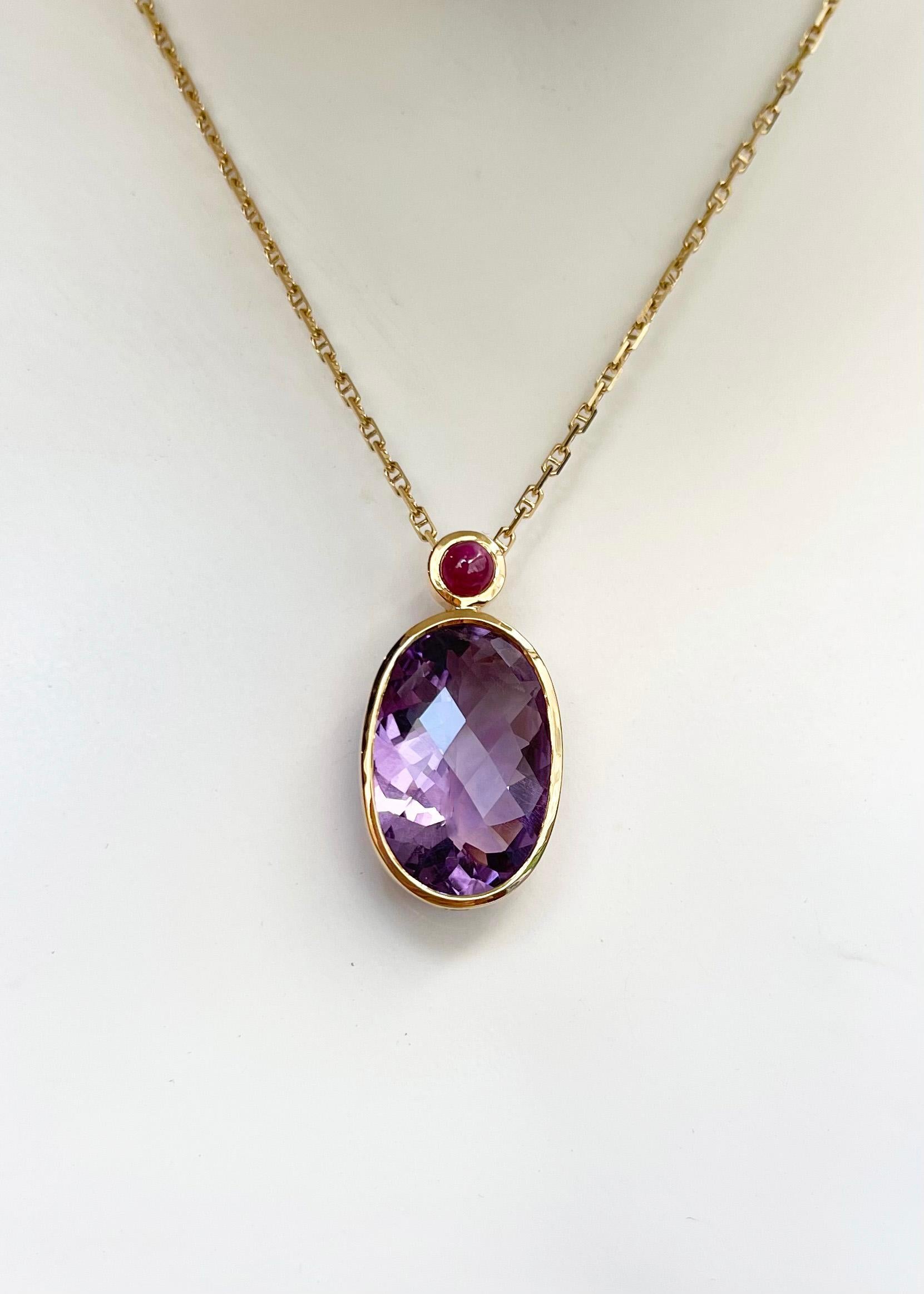 Améthyste 12.95 carats avec Rubis Cabochon 0.62 carat Pendentif serti en or 18K
(chaîne non incluse)

Largeur : 1.5 cm 
Longueur : 3,0 cm
Poids total : 5.92 grammes

