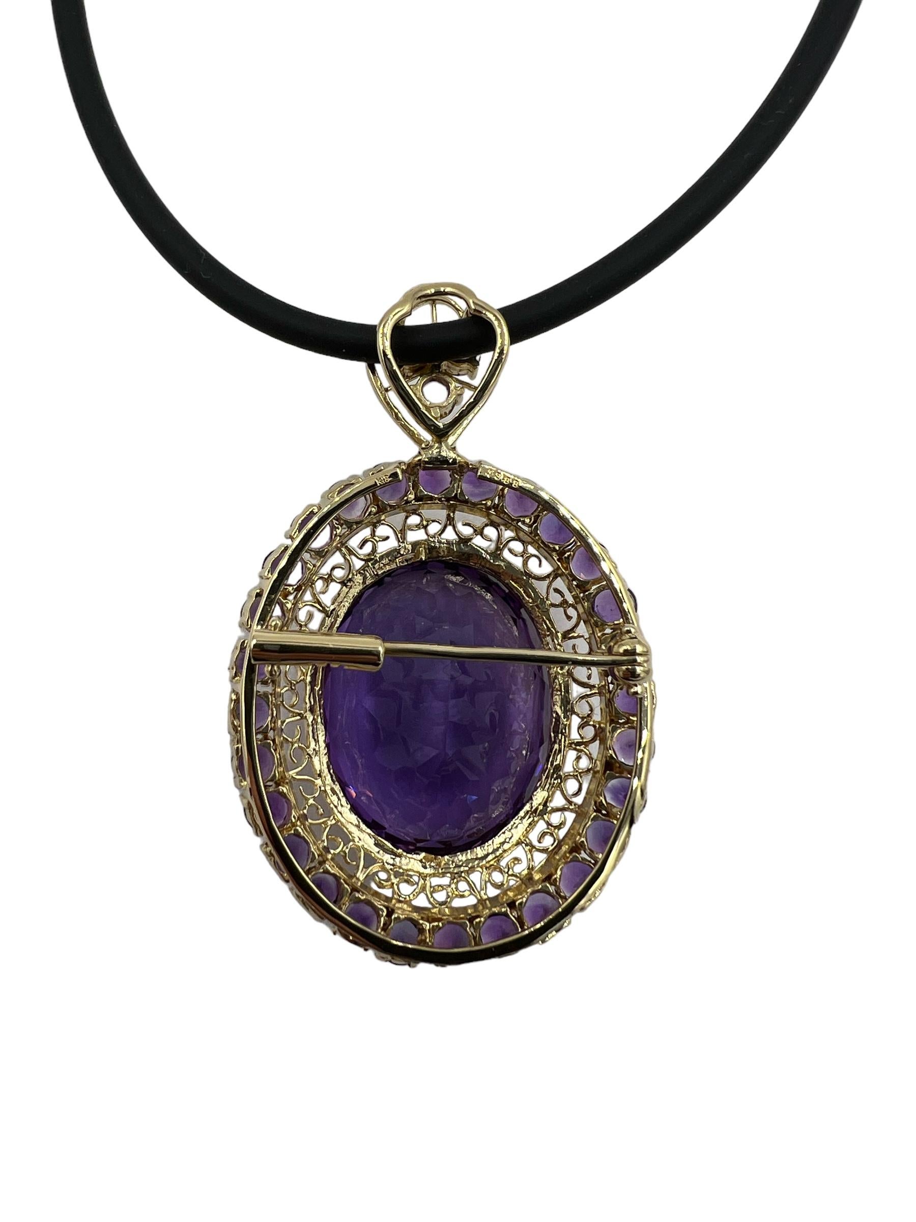 Amethyst Yellow Gold Brooch Pendant on a black rubber cord.

 ABOUT THIS ITEM: P-DJ112F  This Amethyst set Pin/Pendant is a stunning piece of jewelry that exudes elegance and sophistication. With its bold presence, it is sure to make a statement