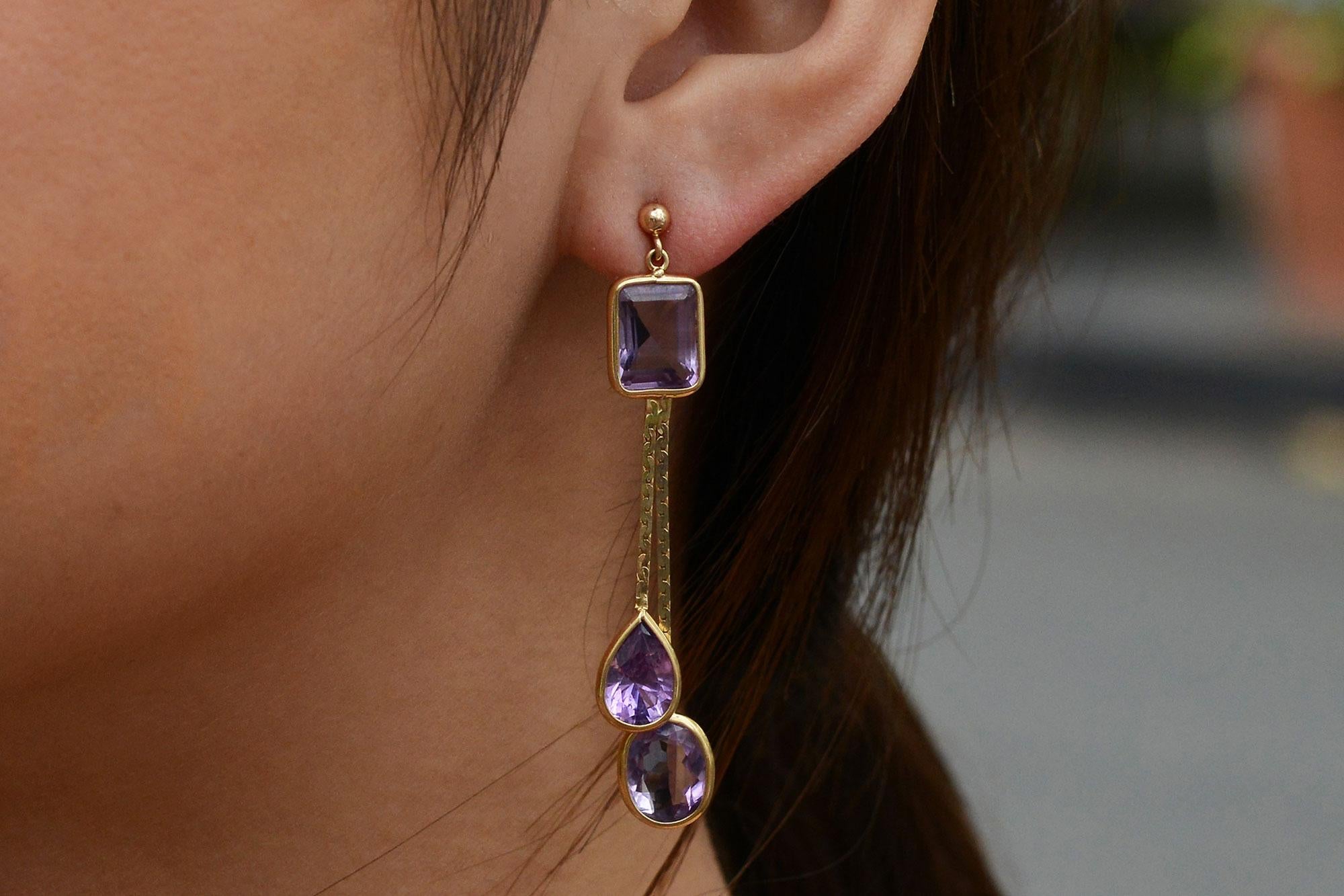 These exquisite dangle earrings are an estate treasure, boasting unique, vibrant lilac amethysts set in 14 karat yellow gold, making them an affordable and sustainable option for the luxury-minded. The interesting, geometric motif features an