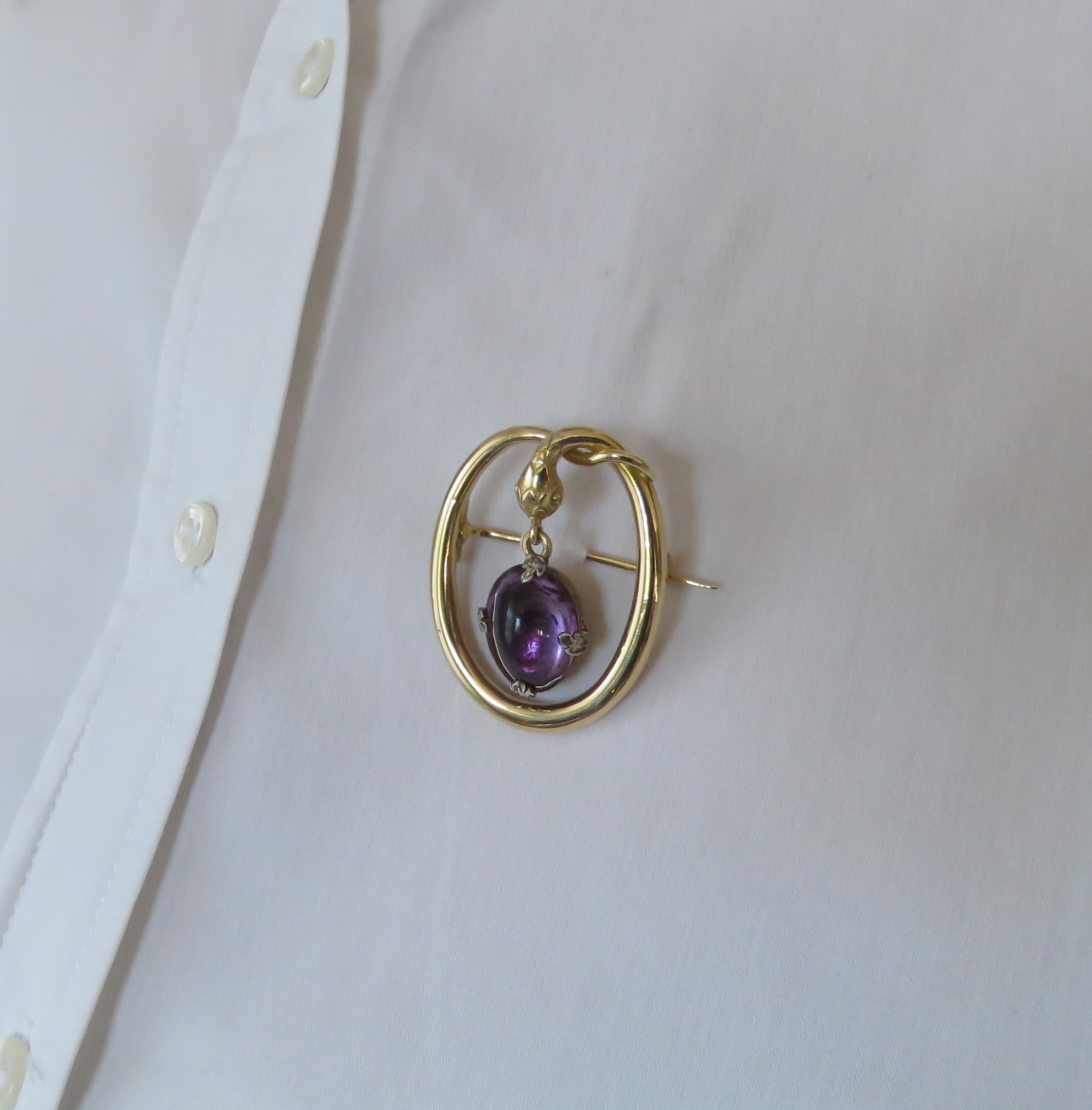 Lovely 18 karat yellow gold snake vintage brooch. The size is 37X30mm / 1.456x1.181 inches.The  amethyst cabochon cut  and oval shaped and is held by 4 claws in 18 karat white gold with 4 rose cut diamonds.  with a safety clasp. Marked with the Mark