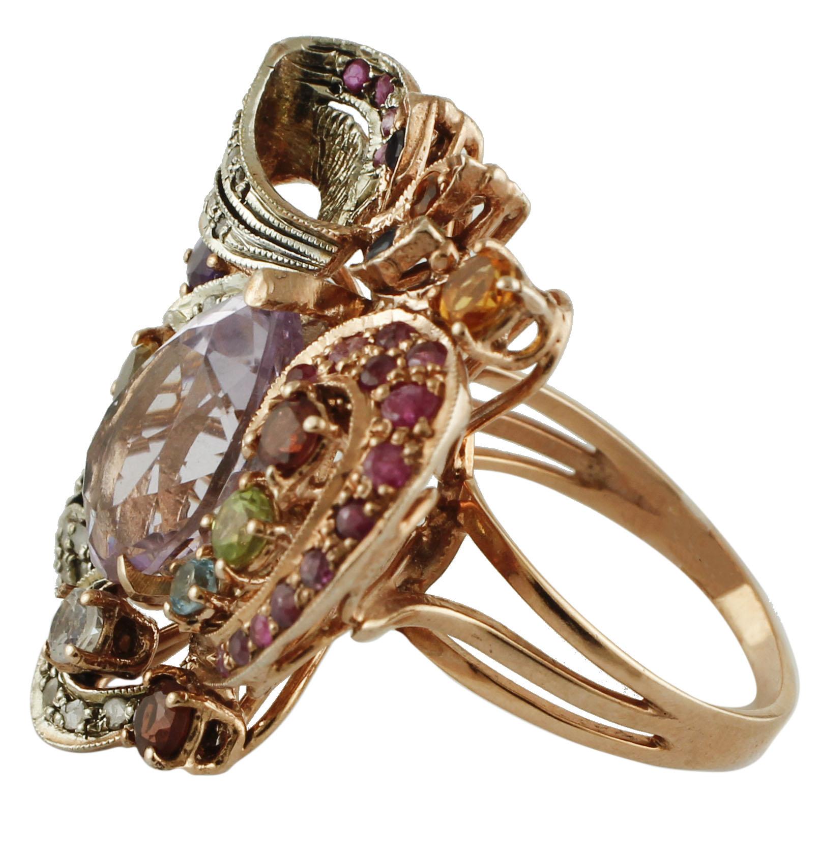 Beautiful retro cocktail ring in 9k rose gold and silver structure, mounted with a central big drop of amethyst, surrounded by flowery decorations in rose gold and silver, studded with diamonds, rubies, blue sapphires, garnets, peridots,and topazes.