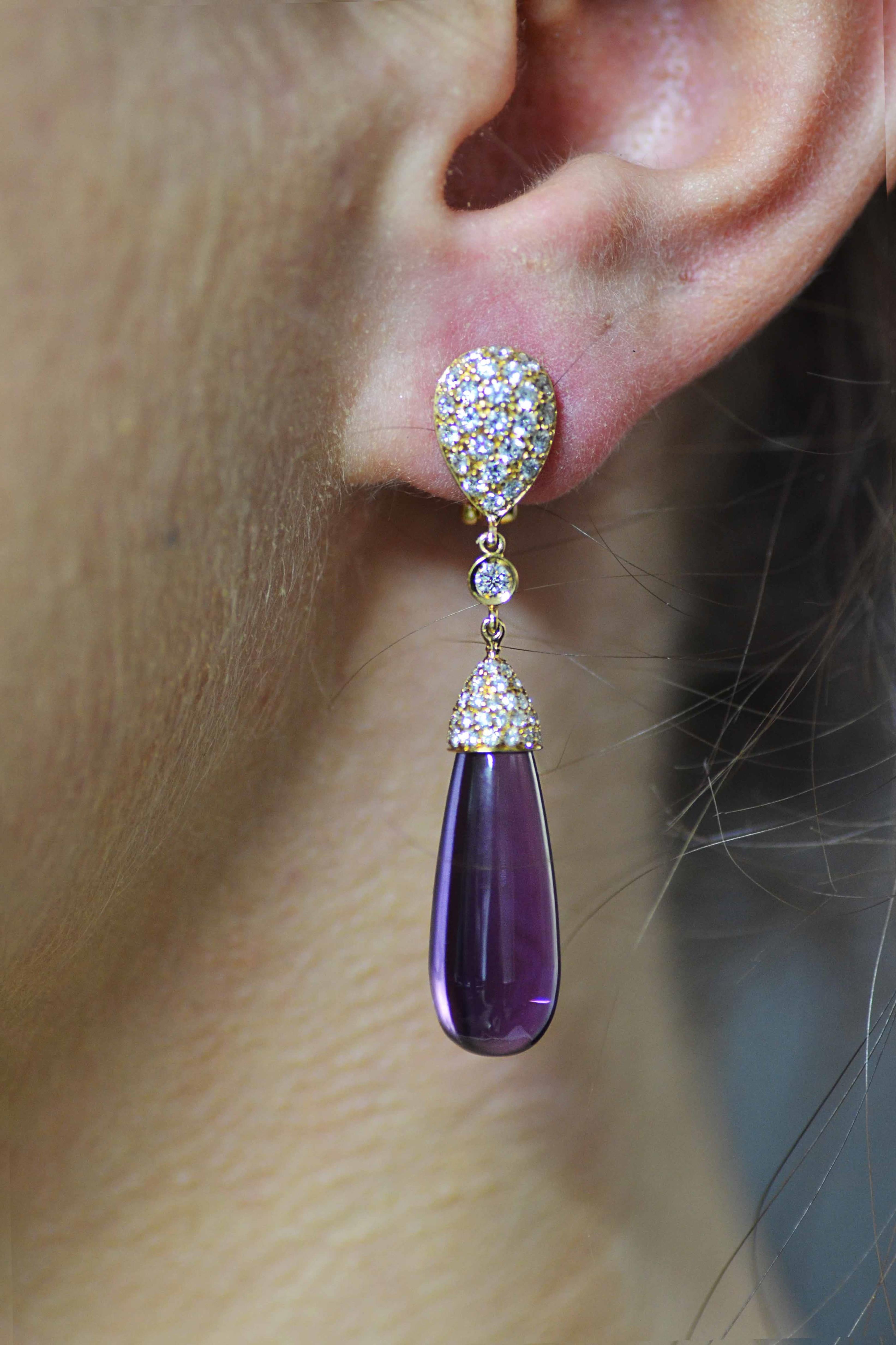 Handmade in Italy, in Margherita Burgener family workshop, in 18 Kt yellow gold and diamonds, these chic earrings feature a long amethyst drop.

they are designed as a diamond pavé set top, single diamond and a diamond pavé set cup on the cabochon