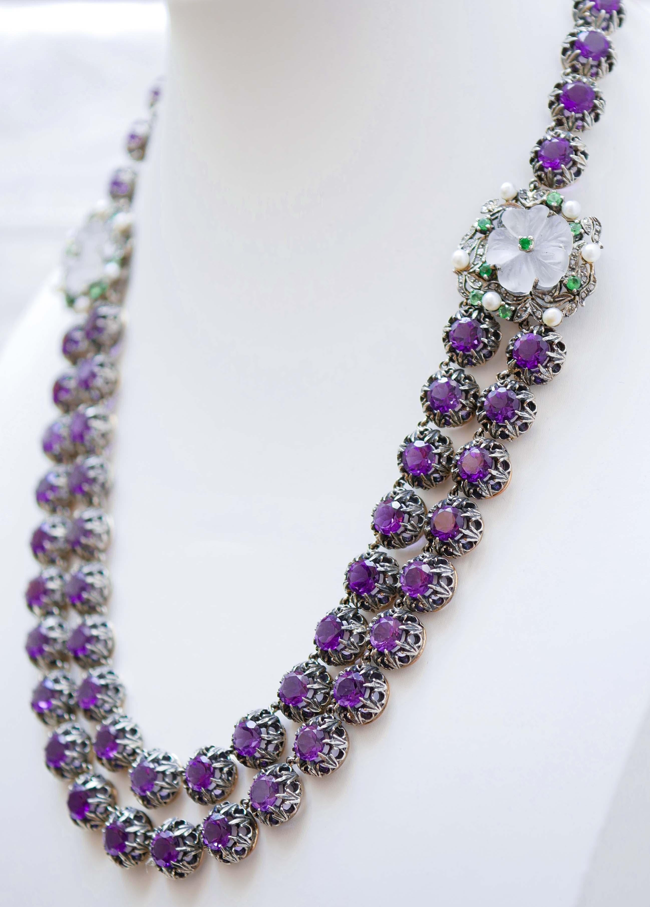 Beautiful necklace in 9 kt rose gold and silver structure mounted with amethysts and two structures mounted with a flower of rock crystal  surrounded by diamonds, tsavorite and pearls.
This necklace was totally handmade by Italian master goldsmiths