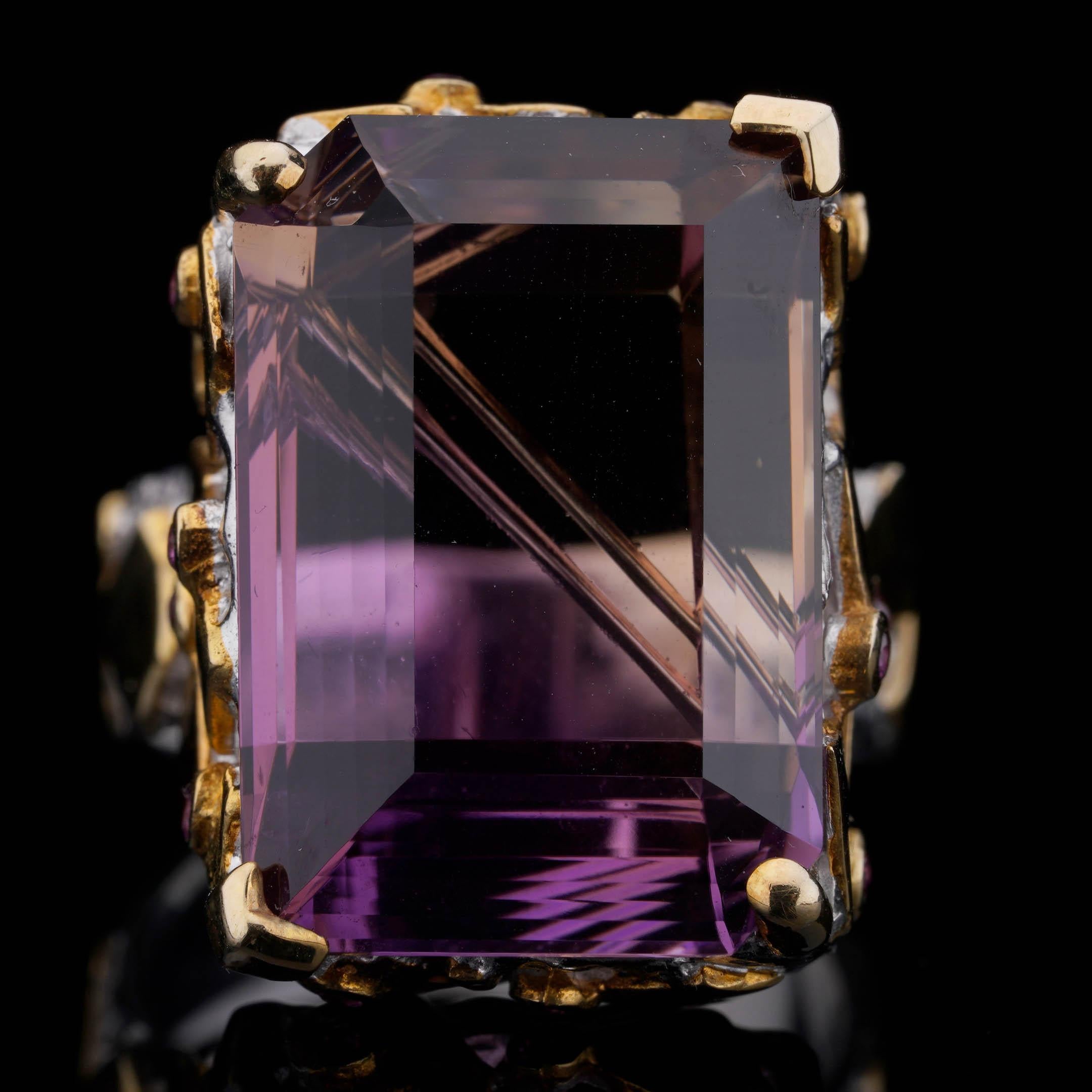 Dieser Designerring zeigt einen großen Ametrin im Smaragdschliff: ein natürlicher zweifarbiger Edelstein, der satte violette Amethyst- und goldene Citrin-Töne in einem einzigen, auffälligen Kristall vereint. Der Stein wurde fachmännisch facettiert,