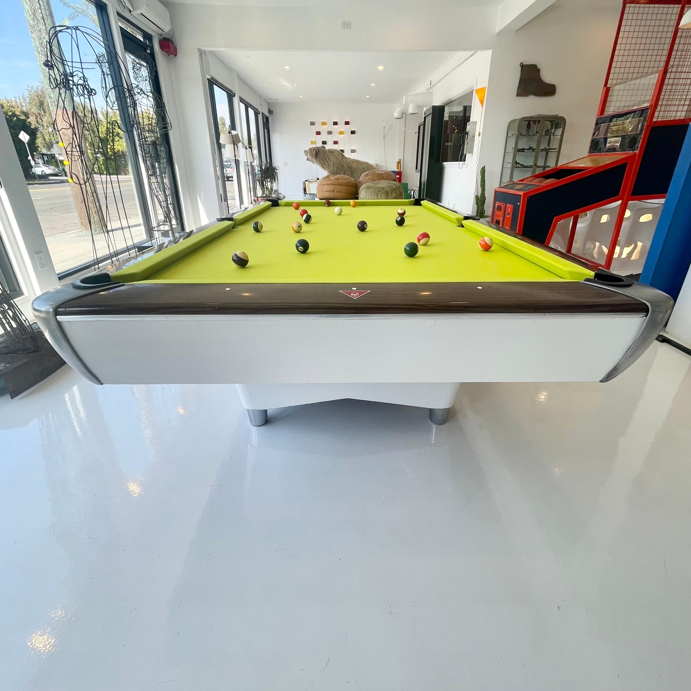 Retro AMF pool table in a stunning slime green felt with wood and chrome accents. Space age lines make this pool table a great statement piece and give it amazing character. Wooden panels and chrome in good condition. Beautiful dual pedestal design