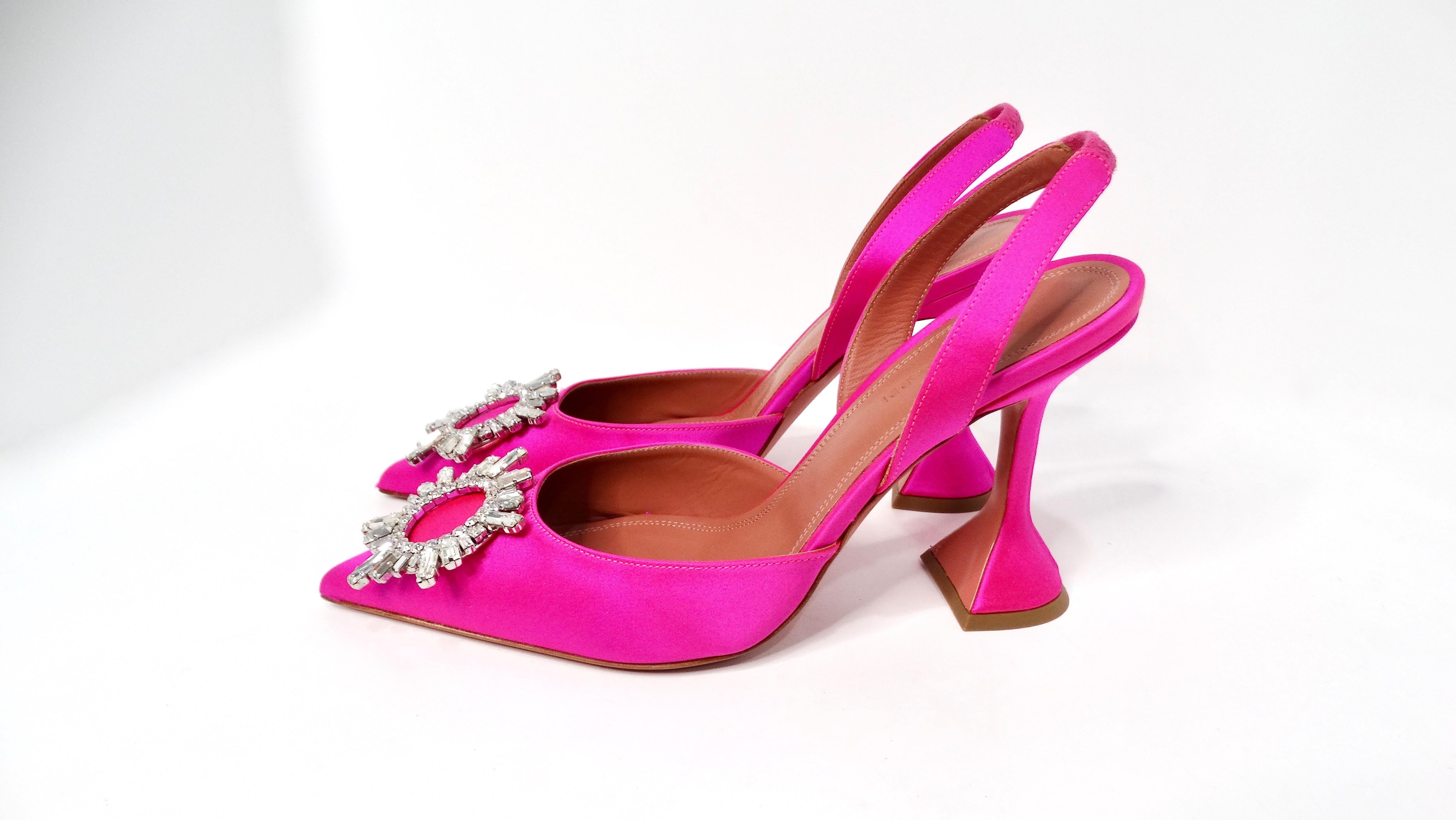 Die Amina Muaddi Begum Hot Pink Satin Slingback Pumps sind eine glamouröse Wahl für alle, die ein mutiges Modestatement setzen wollen. Diese auffälligen Pumps aus kostbarem Satin sind mit einem auffälligen, kristallisierten Sonnenmotiv an der
