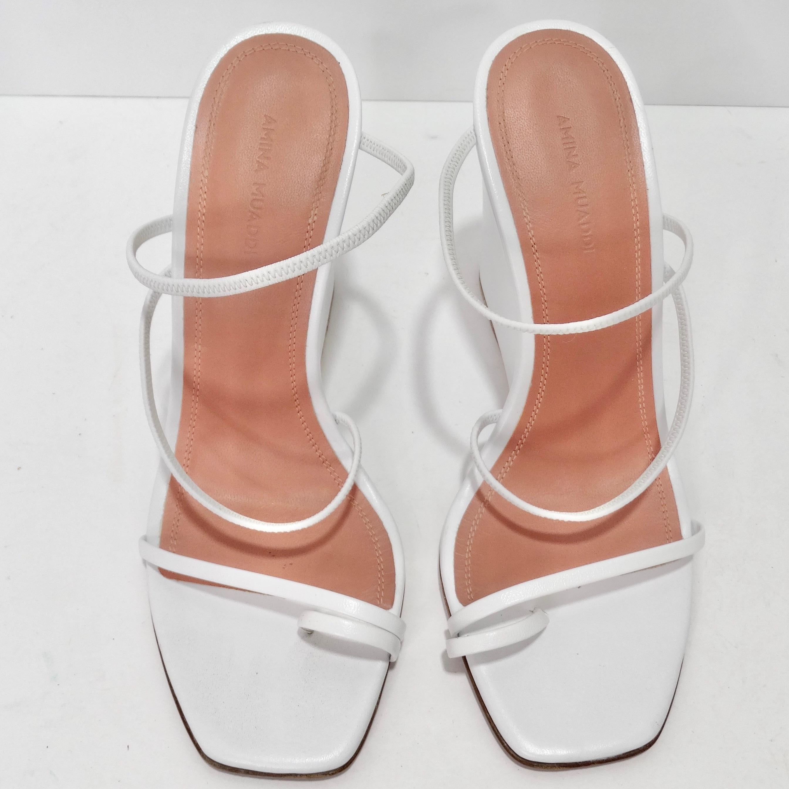 Elevate your footwear game with the Amina Muadi Naima Strappy Wedge Sandals – a perfect blend of style, comfort, and versatility. These white leather wedges are more than just shoes; they are a fashion choice that effortlessly transitions from
