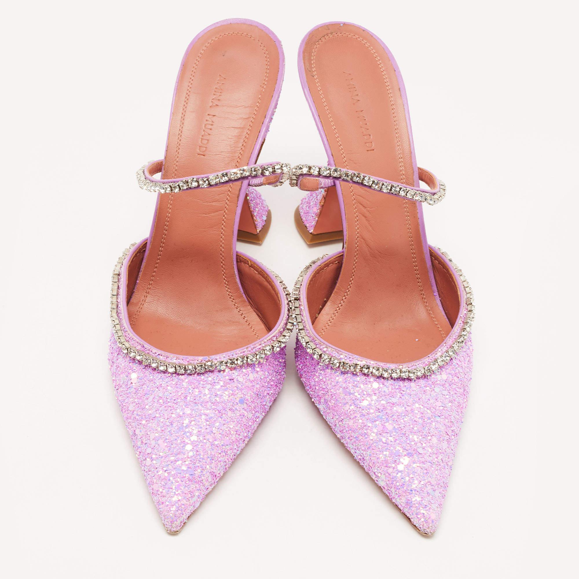 Carved perfectly into a feminine silhouette, this pair of mules from Amina Muaddi accurately denote the label's skilled craftsmanship and style. It is made from coarse glitter in an elegant purple shade. These shoes are finished off with a slingback