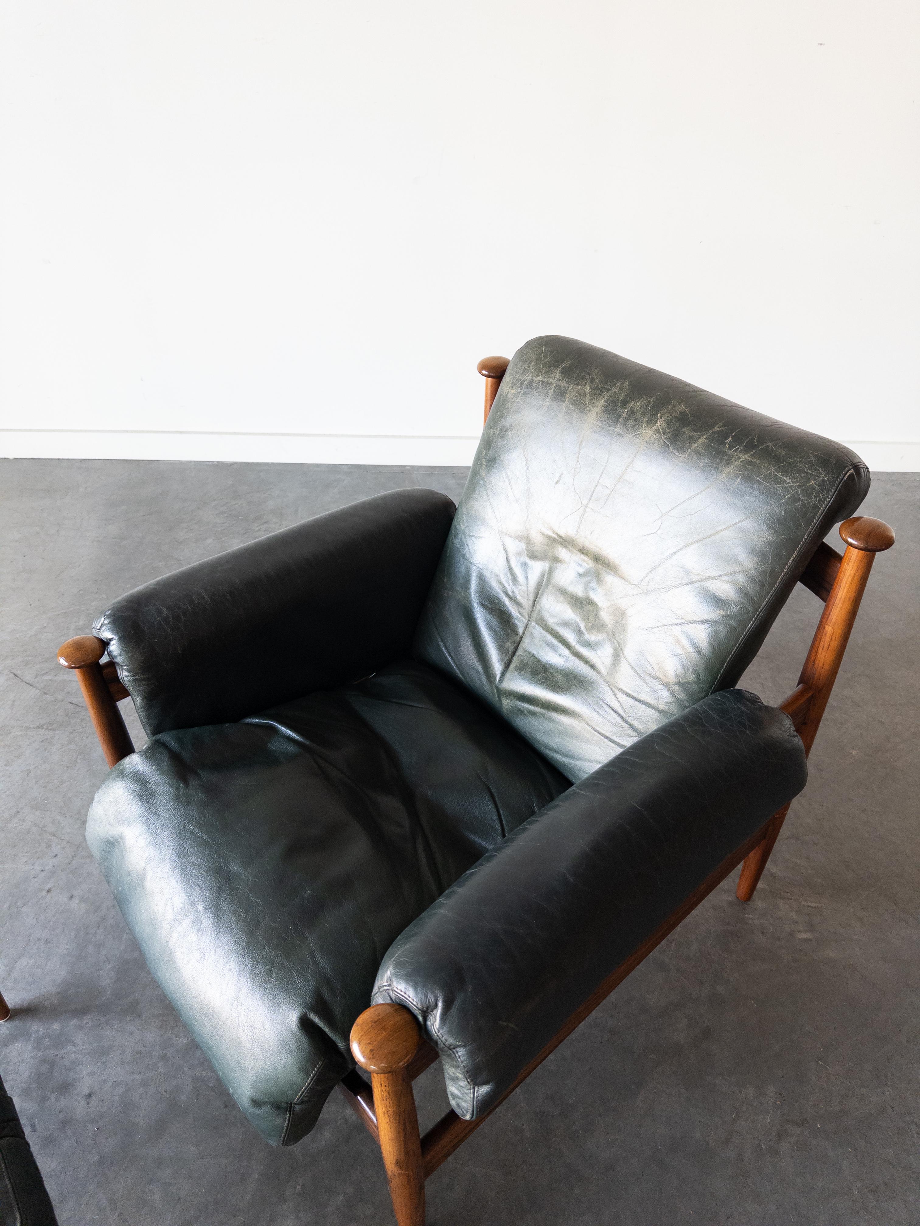 Admiral lounge chair and ottoman designed by Eric Merthen. Produced by Ire möbler in Skillingaryd, Sweden. Rosewood and original green leather. Safari-inspired slung leather silhouette, with buckled straps and comfortably chunky padded