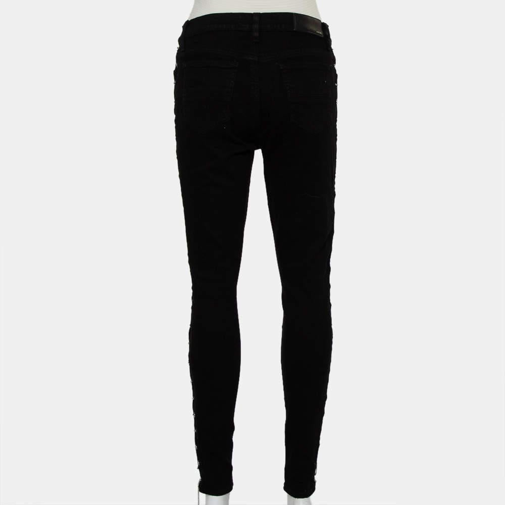 Amiri's skinny jeans are inspired by a rock n roll aesthetic! These denim pants come in a black shade and feature a distressed effect around the knees. The chain detail runs throughout the sides for a rock-chic effect. Team it up with a crop top and
