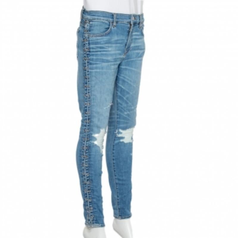 A casual pair of skinny-fit trousers for women by Amiri. Made from a cotton blend, the pair has four pockets, distressed patches on the knees, chain detailing on the sides, front zip-button closure, and a comfortable fit.