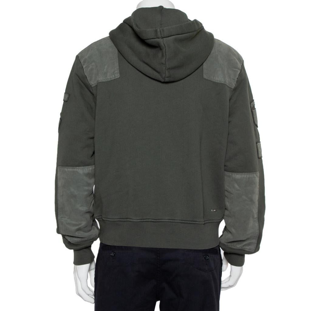 This military green hoodie for men by Amiri is made from quality cotton to give you comfort. It is designed with long sleeves, a hood, and distinct patches all over. This creation deserves a place in your closet.

Includes: Packaging, Store tag