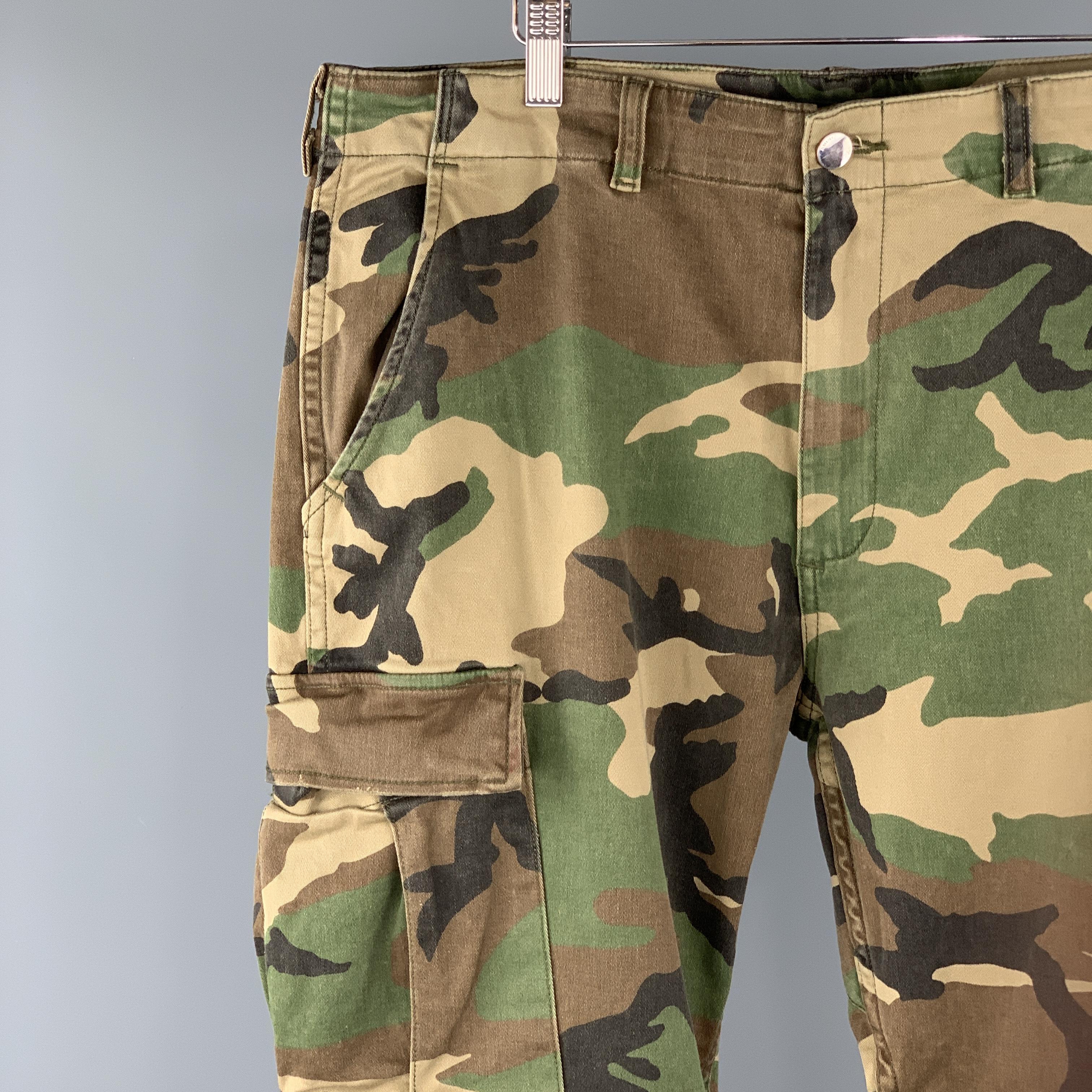 AMIRI casual pants comes in a olive camouflage cotton blend featuring a cargo style, distressed leather kneepad details, patch pockets, and zip fly closure. Made in USA.
 
Excellent Pre-Owned Condition.
Marked: 34
 
Measurements:
 
Waist: 38