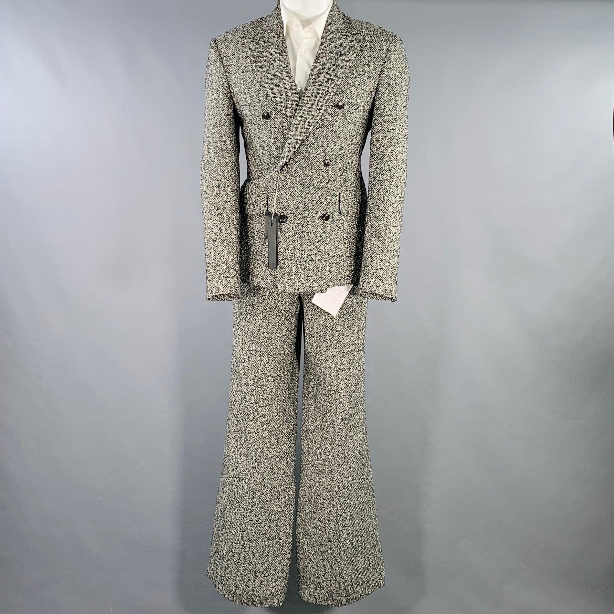 AMIRI suit
in a black and white wool blend tweed with a full liner and includes a double breasted, double button sport coat with peak lapel and matching flat front trousers. Made in Italy.New with Tags. 

Marked:   IT 50 

Measurements: 
 