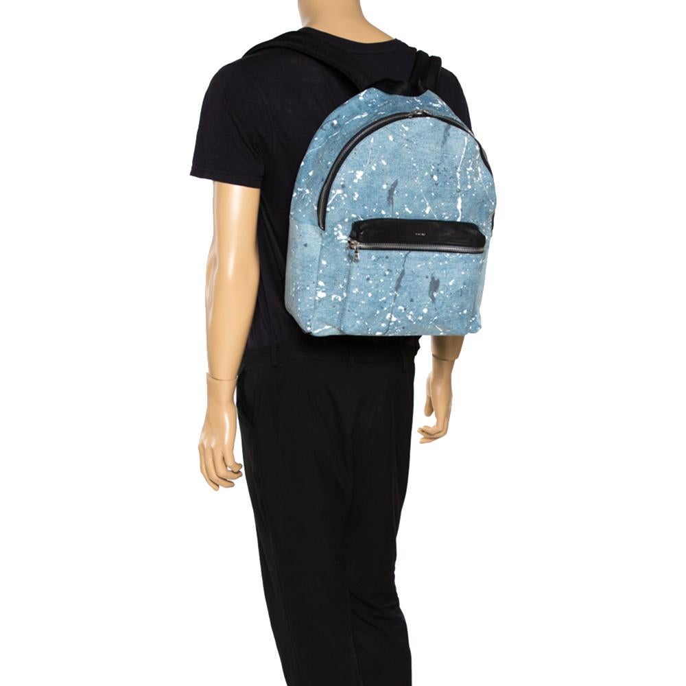 This stylish backpack from Amiri is crafted from denim and leather and enhanced with a paint splatter print all over. The bag features a top handle and adjustable shoulder straps. It flaunts a front zipped pocket with the brand label on it and opens