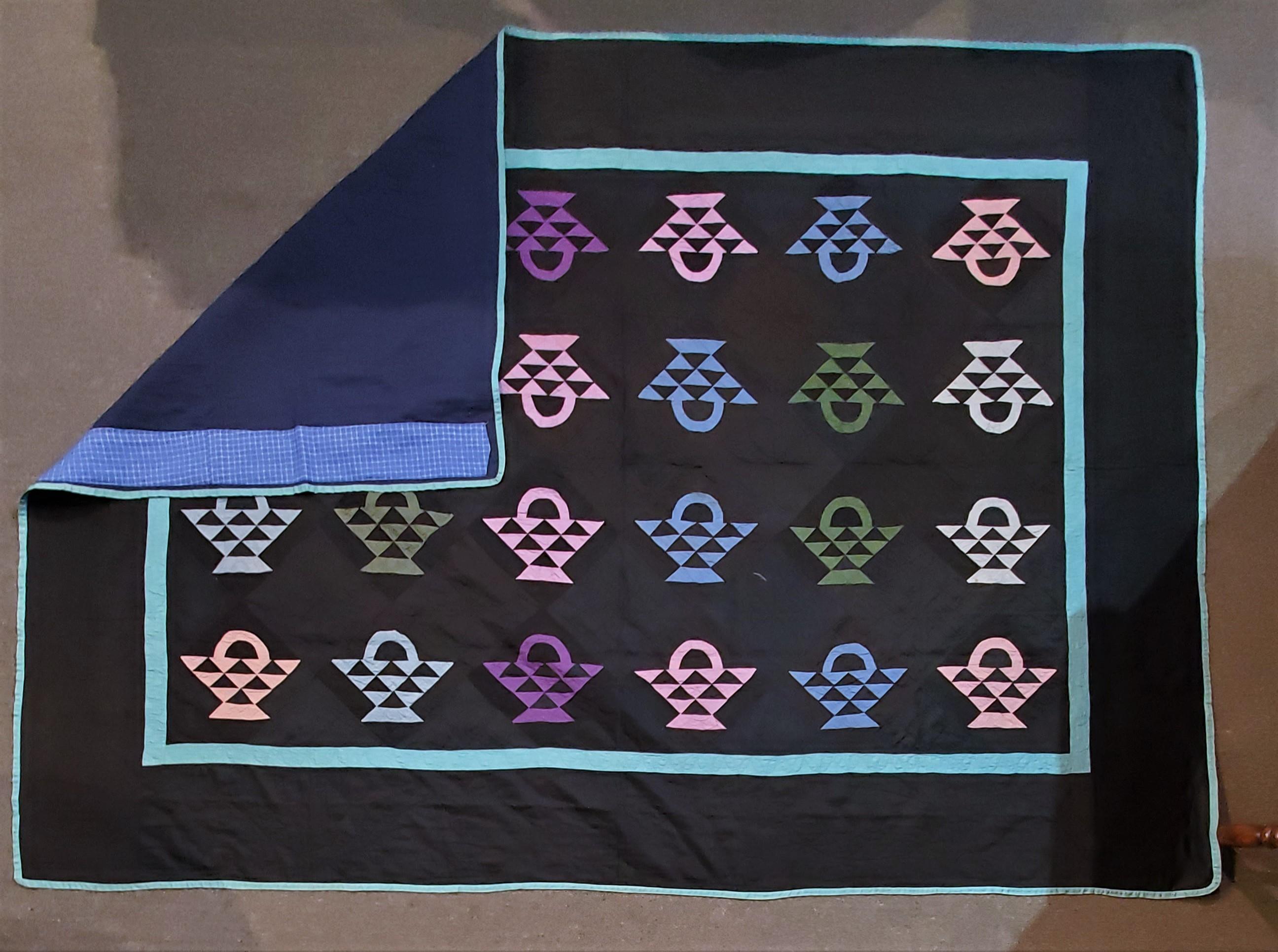 Beautiful authentic Amish quilt from Holmes Co., Ohio,
circa 1930s
The baskets are treadle machine, pieced in various shades of blue, green, pink and purple. Set with black cotton sateen. The inner border and binding are blue-green; it is quilted