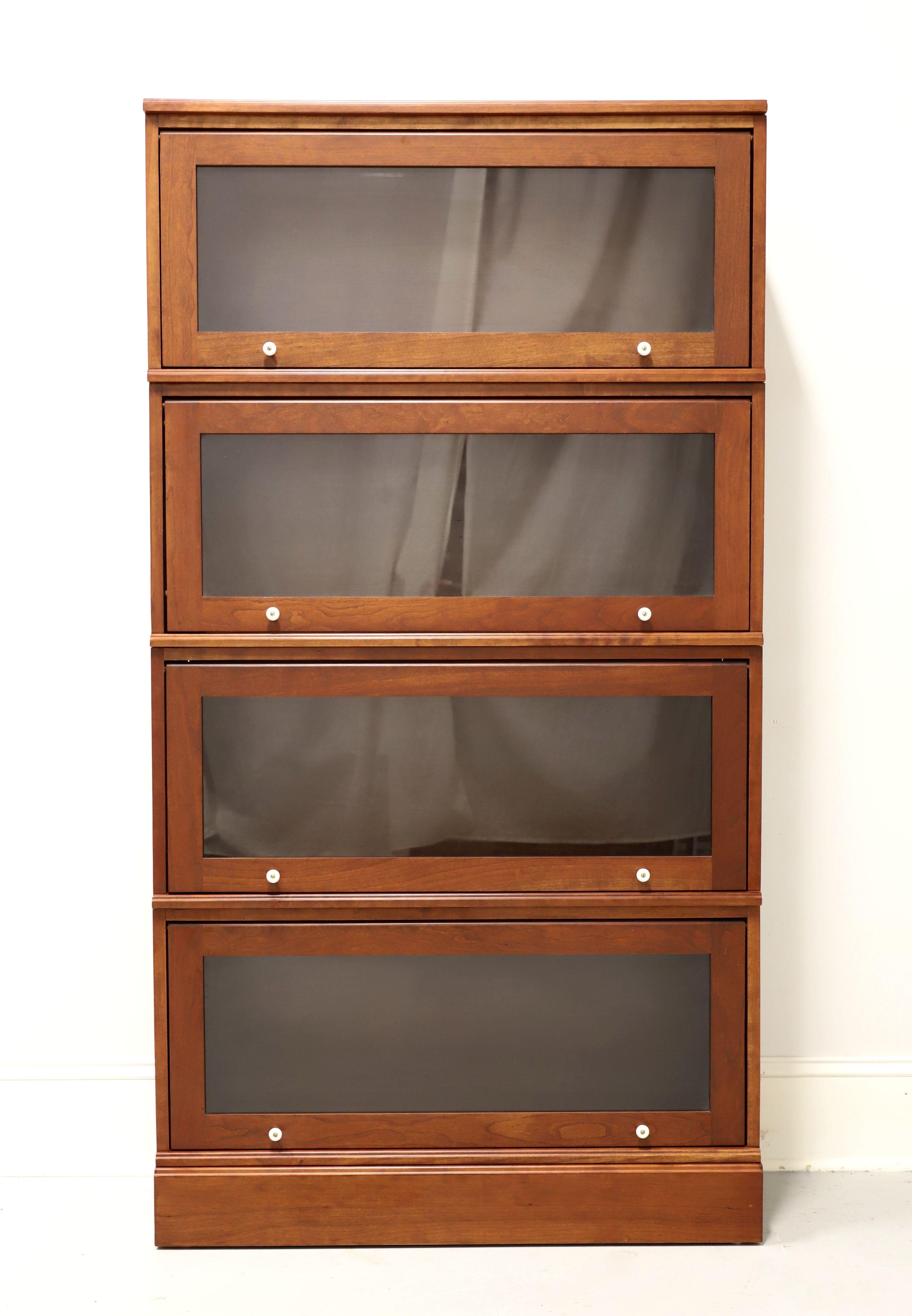 An Arts & Crafts style stacking barrister bookcase by Amish craftsmen. Handcrafted of solid cherry wood with white porcelain knobs, bevel edge to front of top and a solid base. Features the top, four stacking flip up slide back glass door bookcase