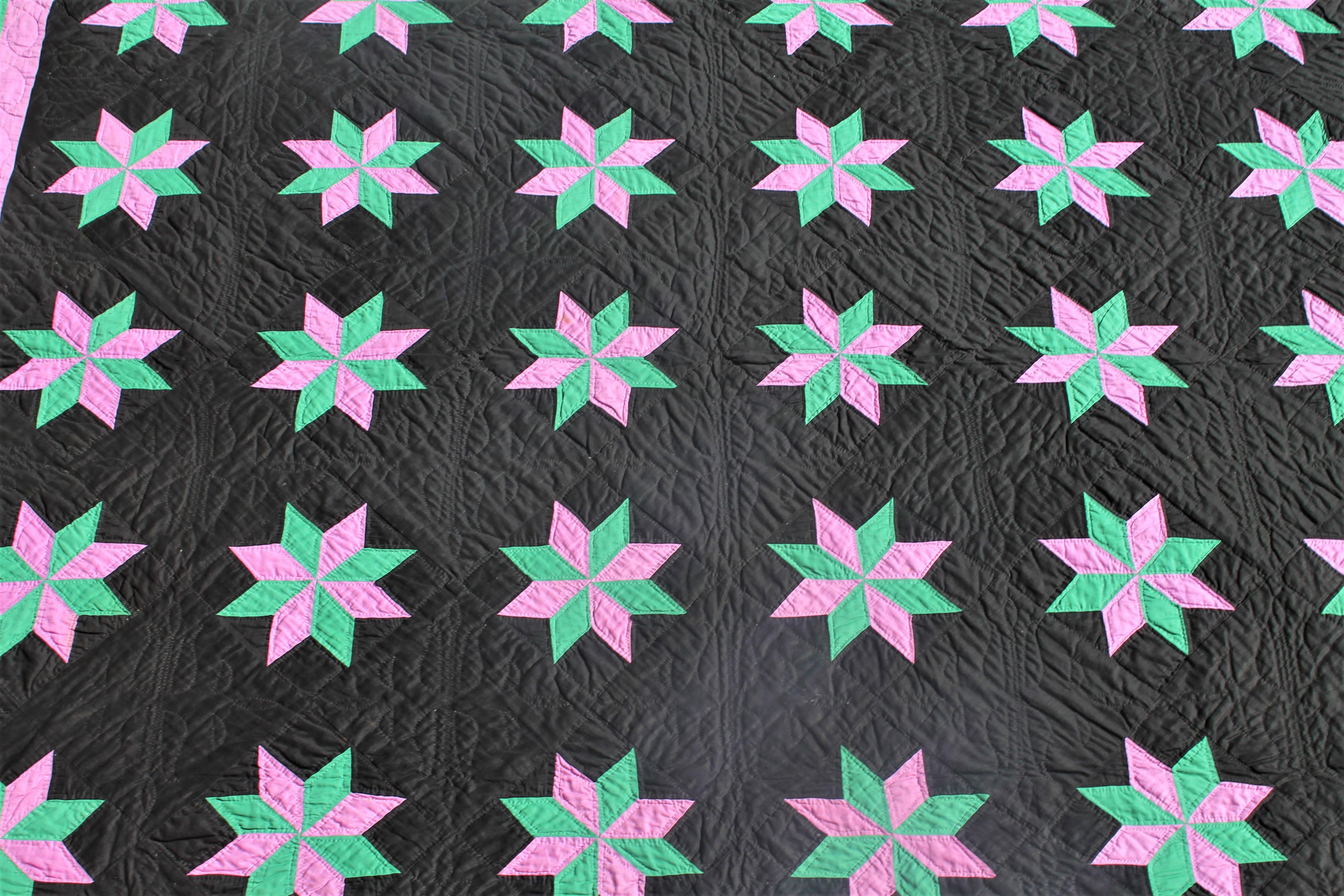 Amish quilt Holmes County Ohio eight point stars on a black ground. The black ground is a polished cotton and eight point stars and a fantastic double inner border. 1930s in pristine condition and fantastic piece work and fine quilting. This is from