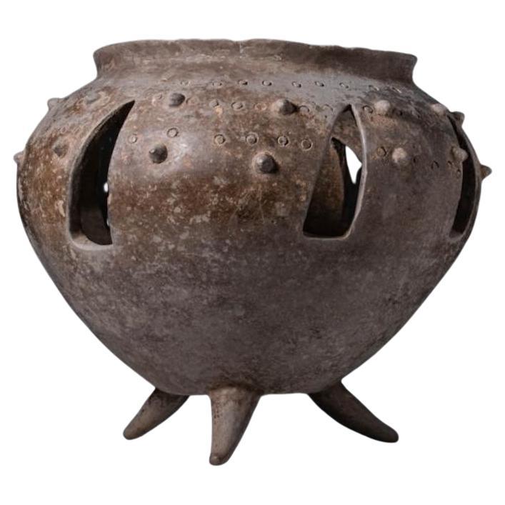 Questo vaso tripode in terracotta traforata di Amlash, risalente al 1200-800 a.C. circa, è un esempio straordinario di artigianato antico proveniente dalla regione dell'Iran nord-occidentale. Realizzato in terracotta, il vaso presenta un corpo