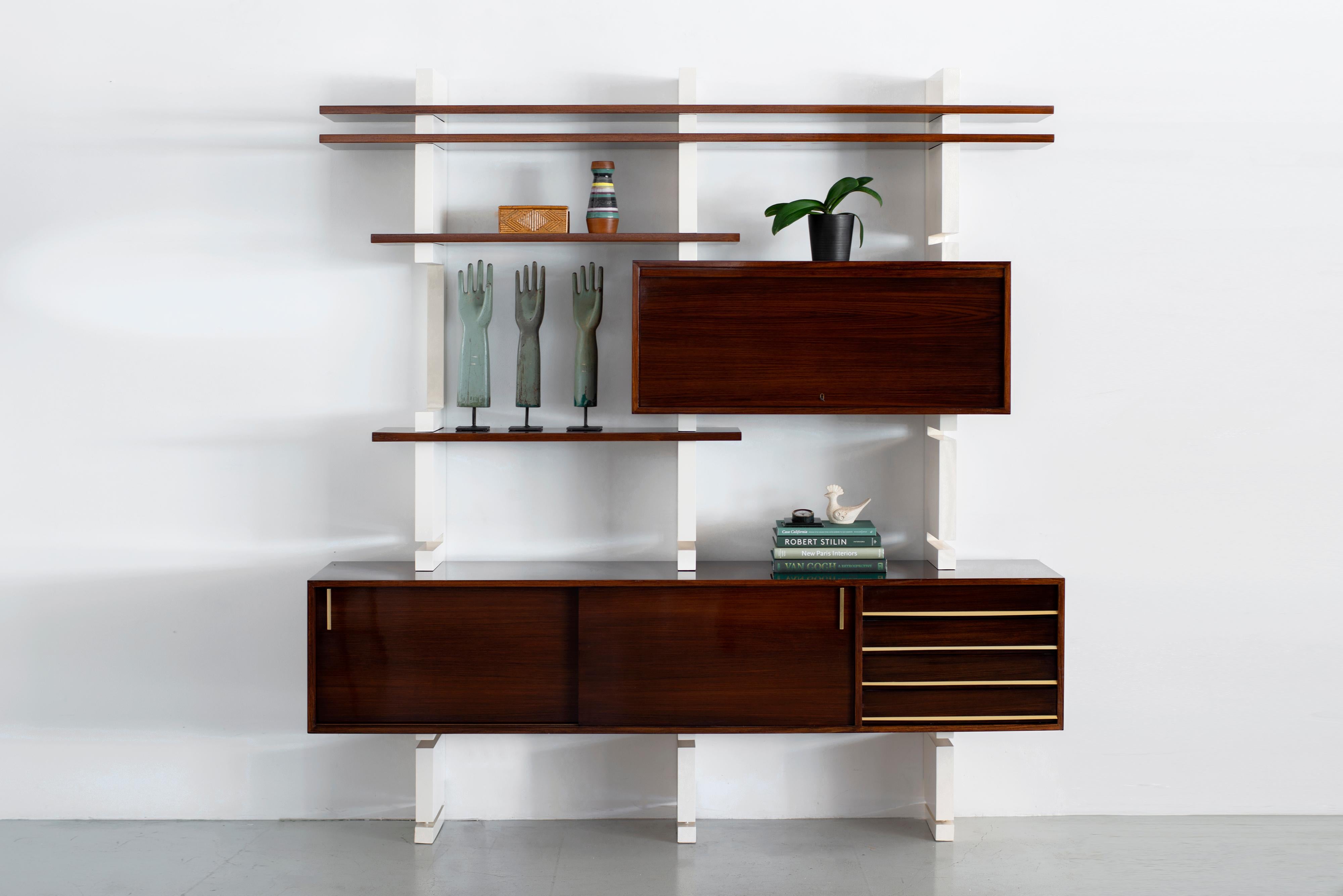 Modular bookcase beautifully refinished - Amma, Turin - Italy, 1960s

Floating rosewood cabinet with brass hardware - adjustable shelves and cabinet that opens to reveal drawers and more shelving. 

Newly lacquered wood supports. 

Gorgeous