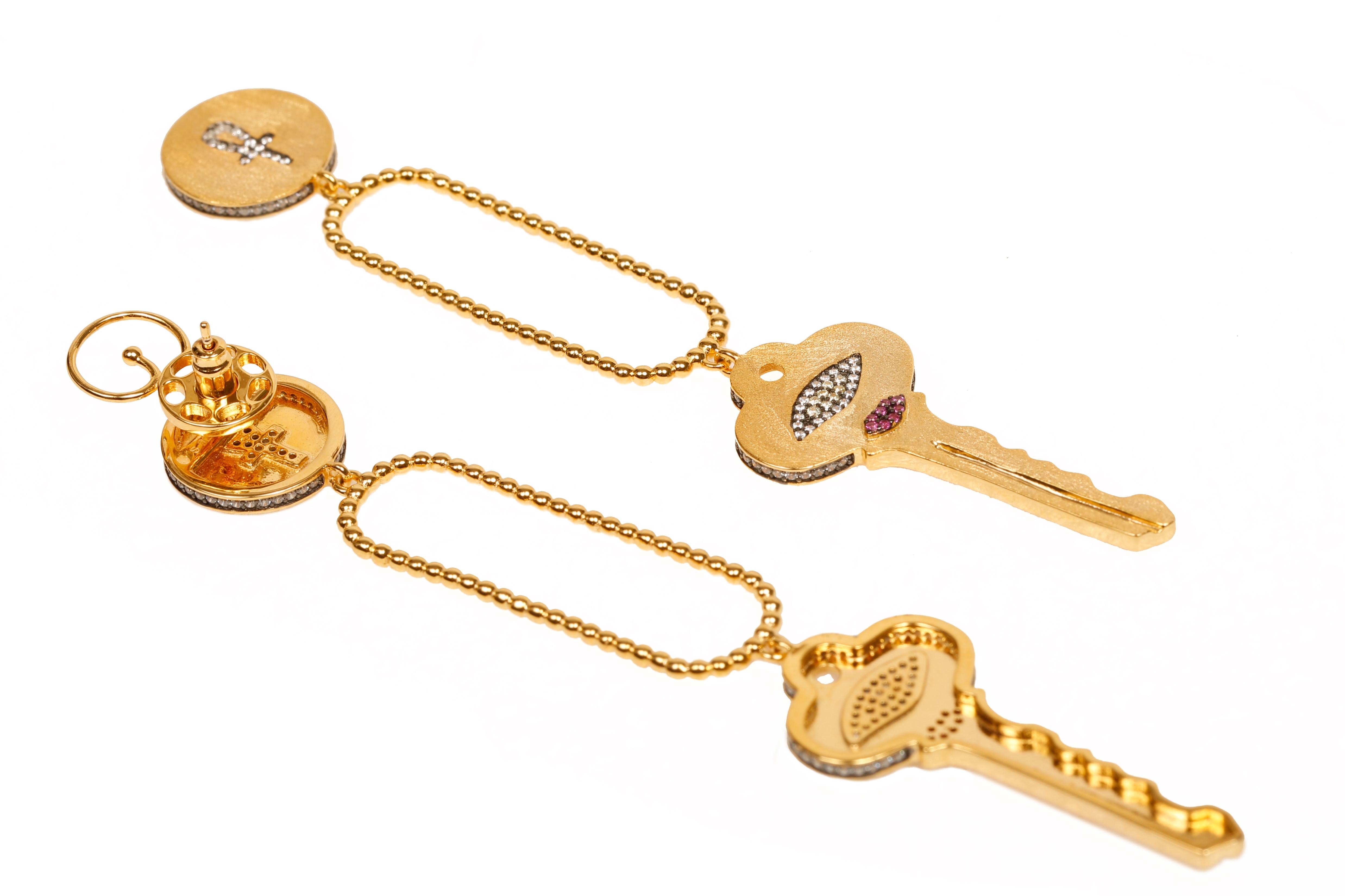 Ces boucles d'oreilles Clé sont fabriquées de main de maître à partir d'une base d'argent sterling plaquée d'or jaune 18 carats, avec une finition satinée et des zircons cubiques de haute qualité sertis à la main. Le symbole de la clé représente la