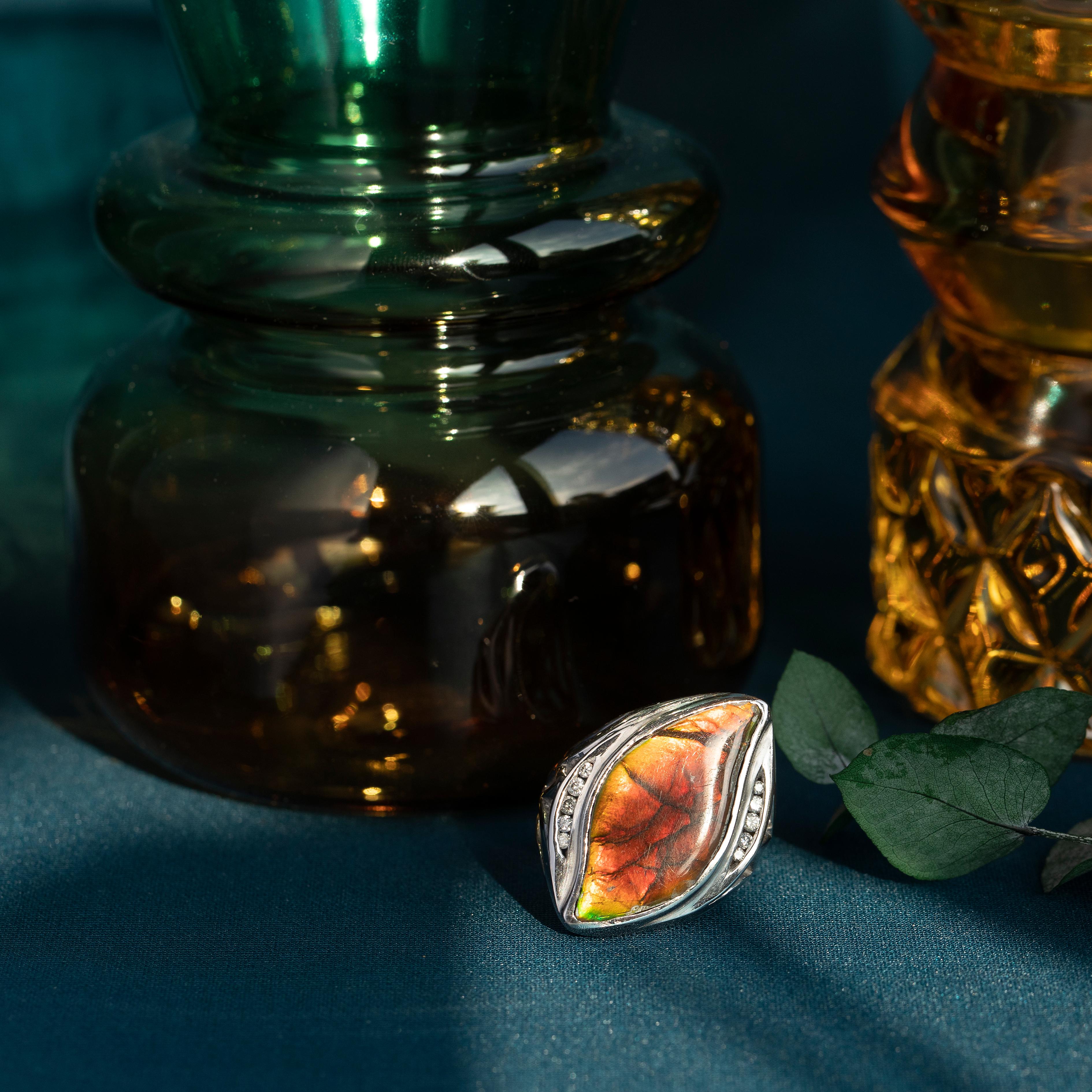 Ti presentiamo un eccezionale anello con la più accattivante e vibrante pietra centrale in ammolite. Accentuato su entrambi i lati da 5 diamanti di colore G e purezza SI, per un peso totale di 0,15 carati.

Con un peso di 19,1 grammi di oro bianco