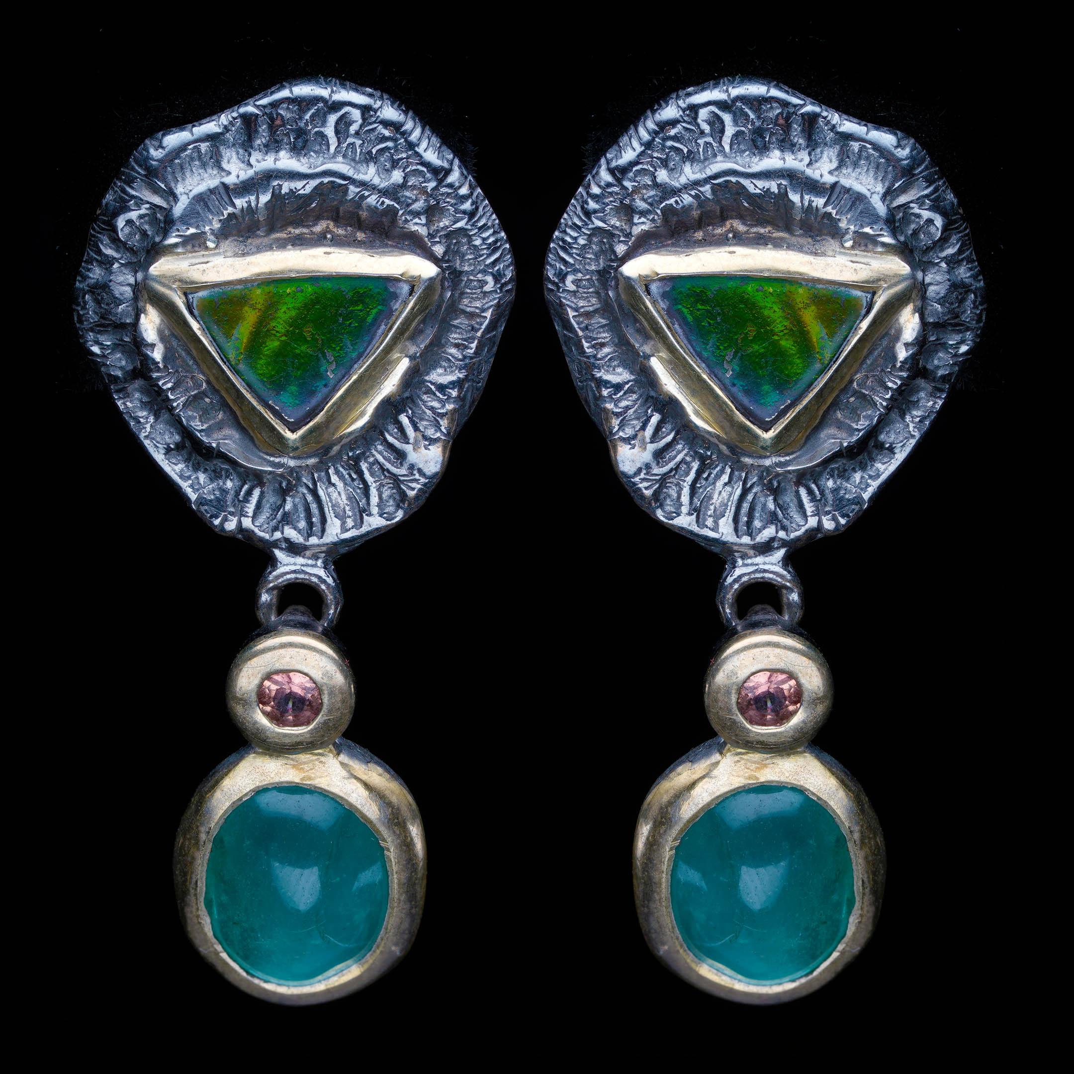 This captivating artisan earring set showcases a bold and colorful mixture of fine gemstones in a sculptural, handcrafted design. Each earring features striking natural Ammolite with electric green and violet play-of-color, bezel-set in rich 14K