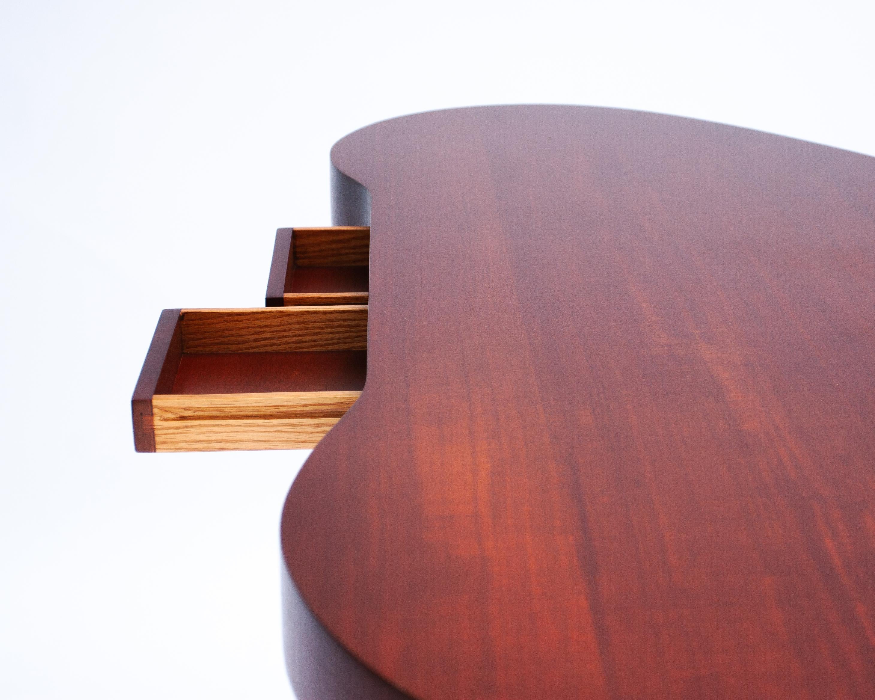 The Paul Frankl Amoeba Desk is an iconic piece of mid-century modern design that exemplifies the seamless blend of form and function. Designed in the 1940s by Paul Frankl, a pioneering figure in American modernist furniture, the desk features a