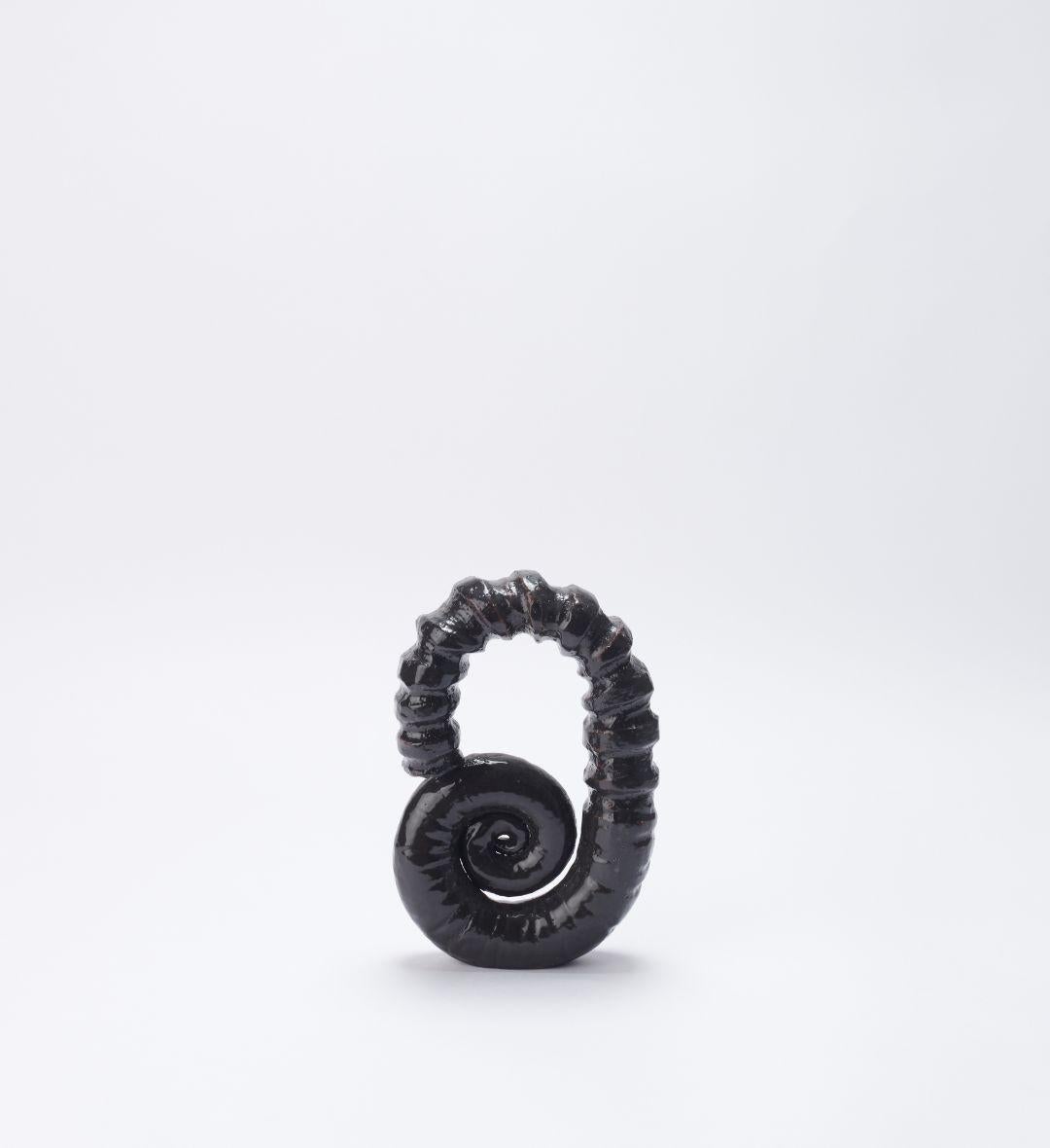 Dekoratives Objekt „Amonite 01“ von Joana Kieppe
Einzigartiges Stück.
Abmessungen: T 5 x B 14 x H 22 cm.
MATERIALIEN: Lotus-Hochtemperatur-Ton mit schwarzer Glasur.

Alle Stücke werden aus hochwertigem brasilianischem Wildton hergestellt, die