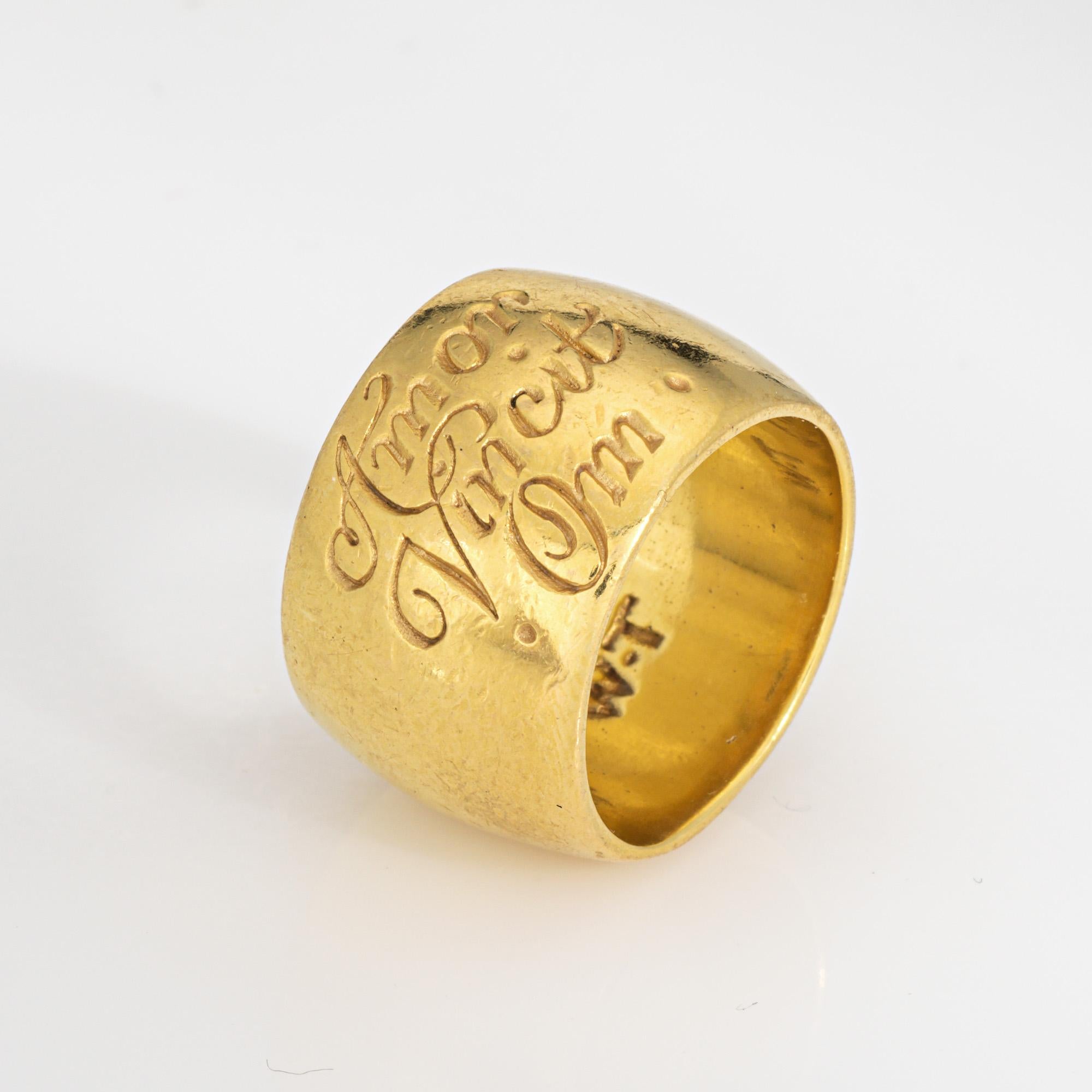 Elegante anello a fascia larga con iscrizione immobiliare realizzato in oro giallo 18 carati. 

Realizzata dall'azienda britannica di gioielli Wright & Teague, la fascia fatta a mano reca l'iscrizione in latino medievale 