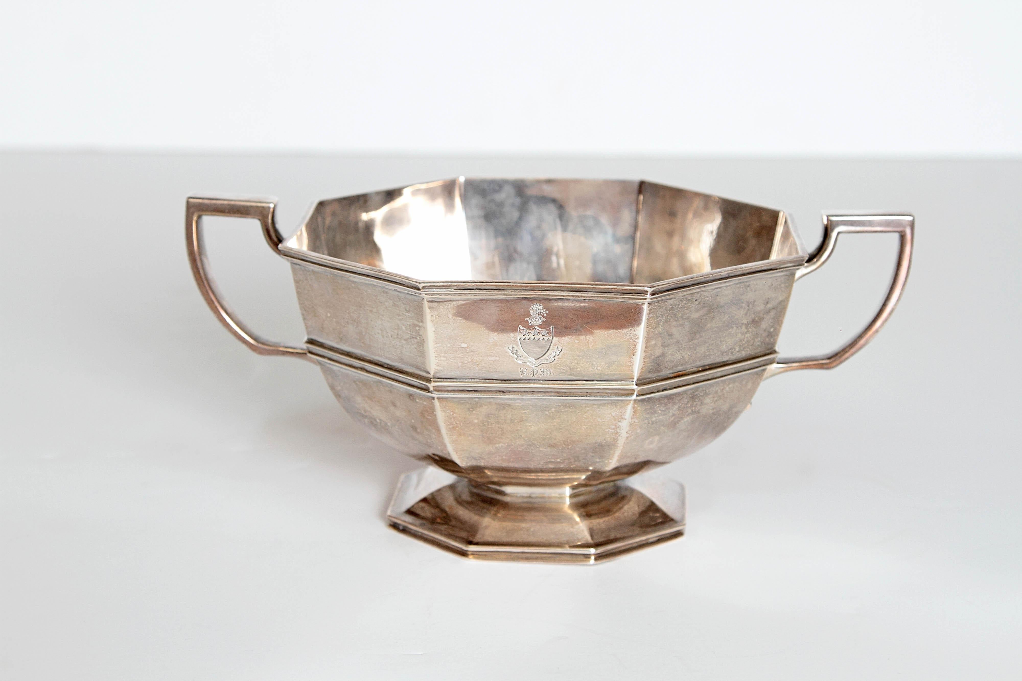 An English Georgian-style sterling silver cup/bowl has an octagonal paneled and rounded form to a spreading pedestal foot. The surface is plain with a cord decoration and incising at top. The underside bears the retailer's mark. Marked made in