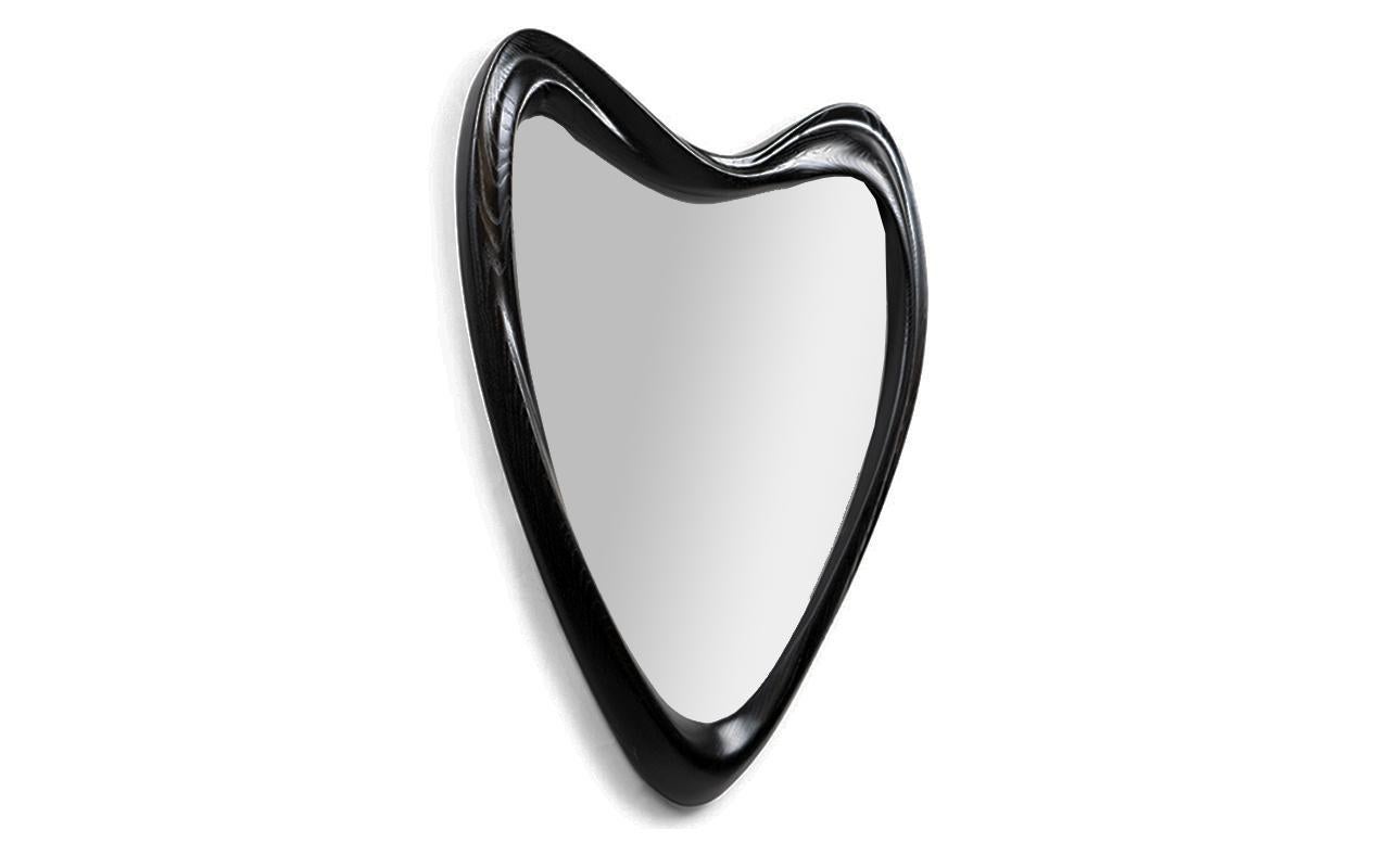 The Celine Mirror is a stylish and modern addition to any contemporary home. Its unique triangular shape adds a touch of elegance and sophistication to any space. The organic shape of the mirror sets it apart from traditional rectangular or circular