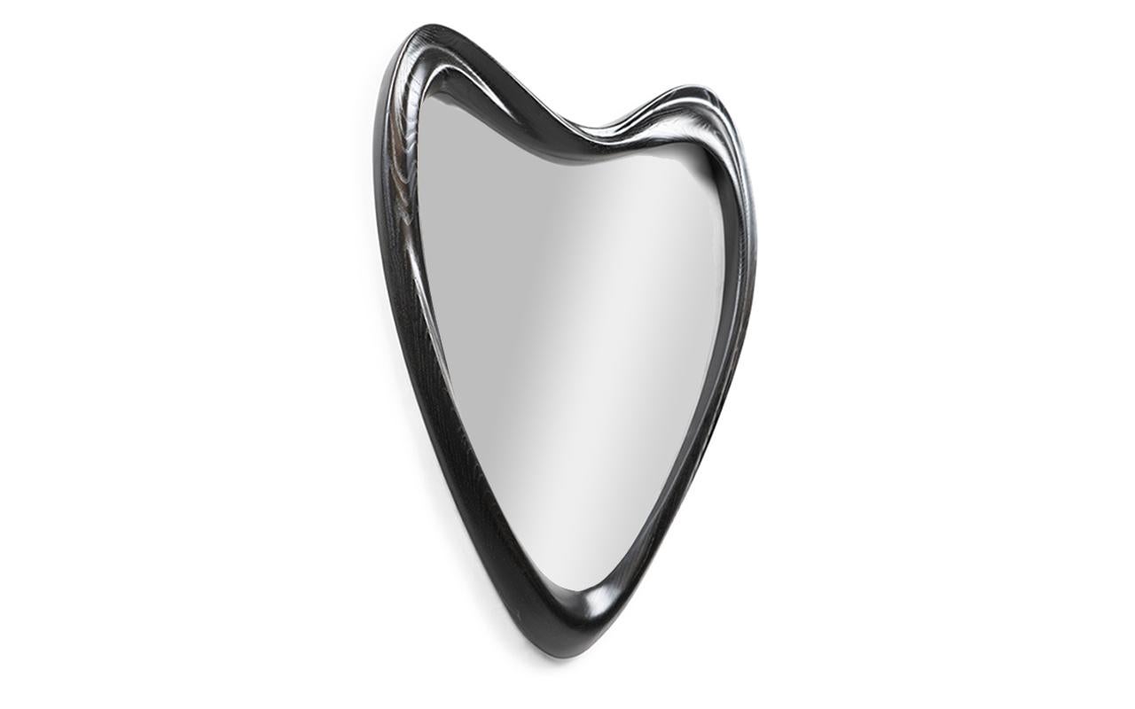 e miroir Celine est un ajout élégant et moderne à toute maison contemporaine. Sa forme triangulaire unique ajoute une touche d'élégance et de sophistication à tout espace. La forme organique du miroir le distingue des miroirs rectangulaires ou