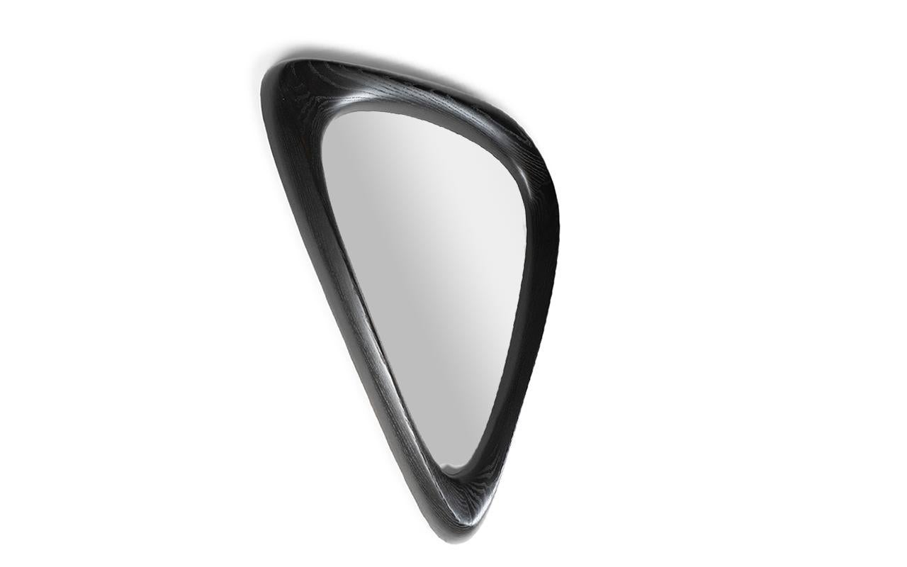 The Cuneat Mirror is a stylish and contemporary addition to any modern home. Its unique triangular shape sets it apart from traditional rectangular mirrors, adding a touch of organic and modern design to your space. The mirror is available in