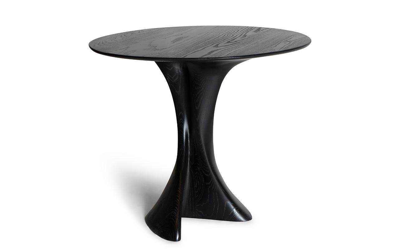 Dervish is a one-of-a-kind round dining table that stands out with its organic shape leg. This unique design adds a touch of elegance and sophistication to any dining space. The table can be customized with a stone top, offering a luxurious and