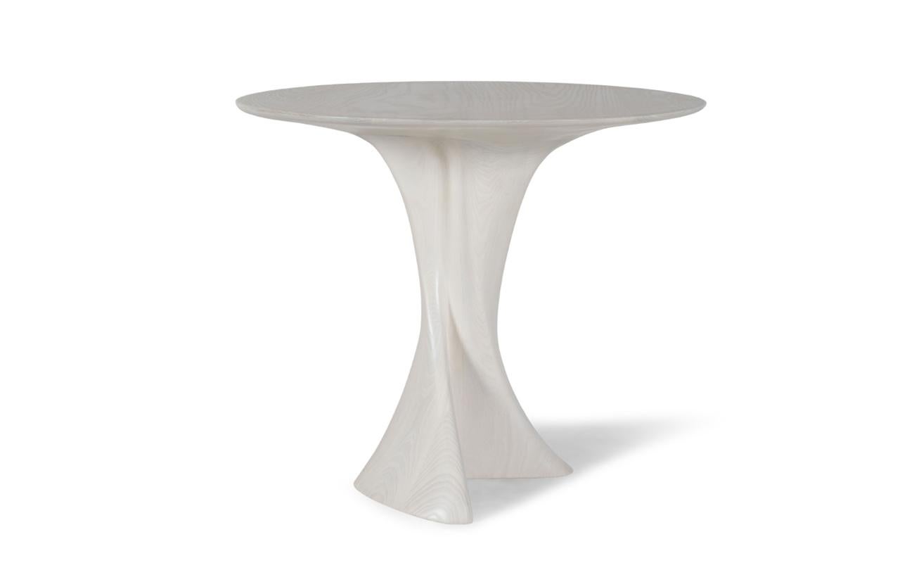 Dervish is a one-of-a-kind round dining table that stands out with its organic shape leg. This unique design adds a touch of elegance and sophistication to any dining space. The table can be customized with a stone top, offering a luxurious and