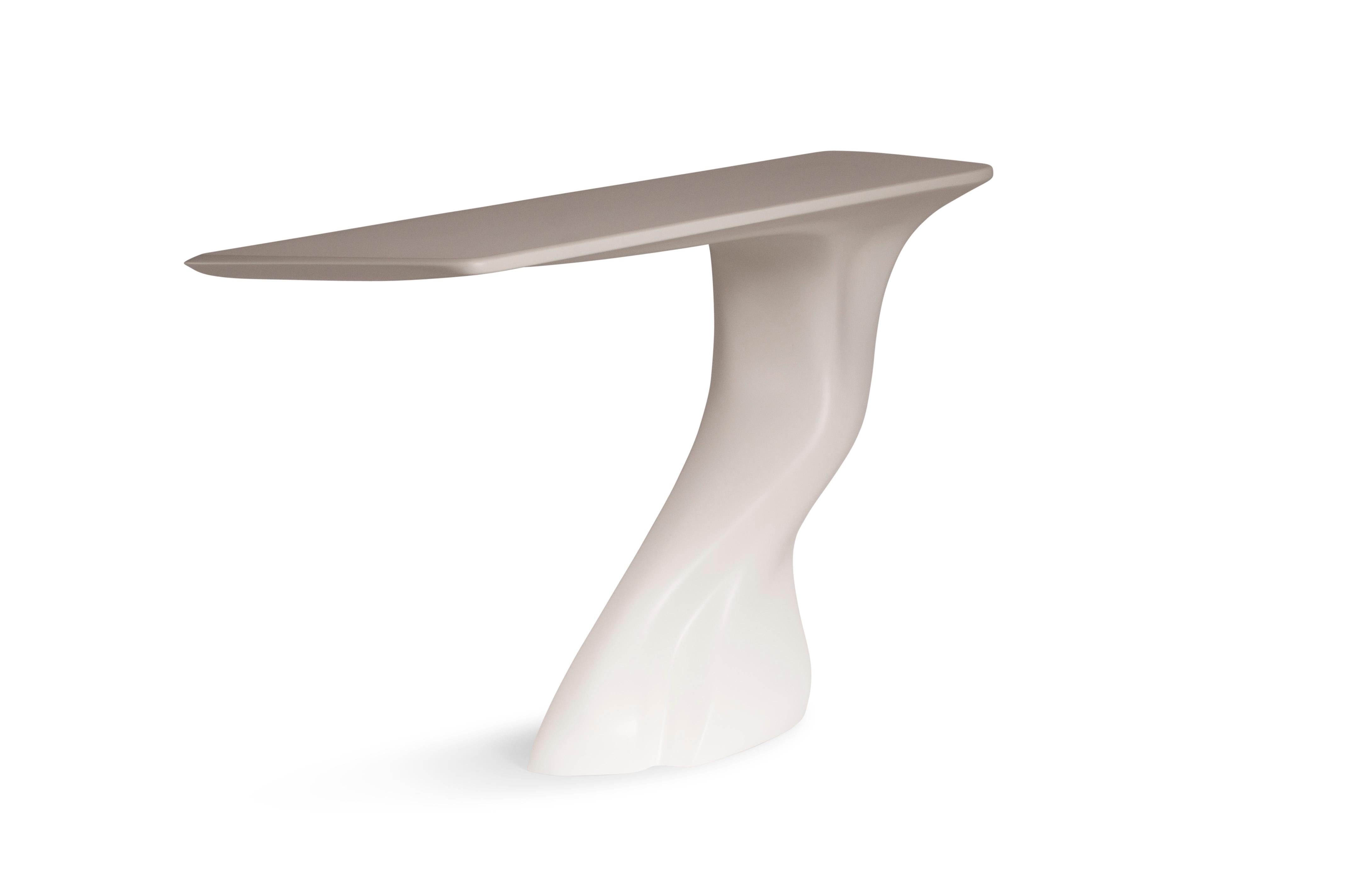 La table console Frolic est une élégante table d'art sculpturale futuriste à la forme dynamique, conçue et fabriquée par Amorph. La table console Frolic est fabriquée en bois avec une finition laquée matte blanche. Par nature, l'aspect du bois de