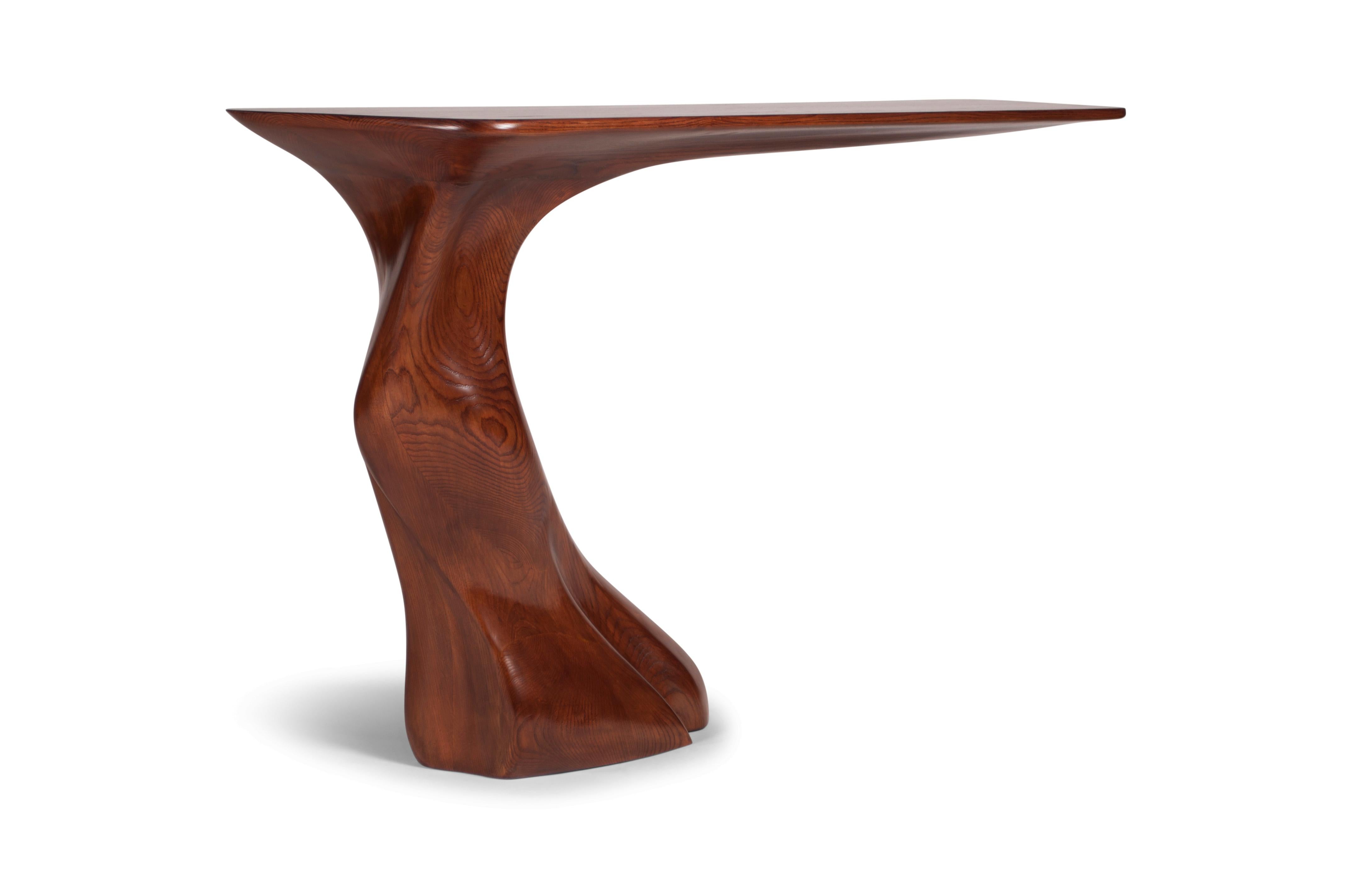 The Frolic console table is a one-of-a-kind piece that stands out with its unique shape and design. This wall-mounted console table features a cantilevered part that is supported by an adjustable bracket, adding to its modern and sleek look. What