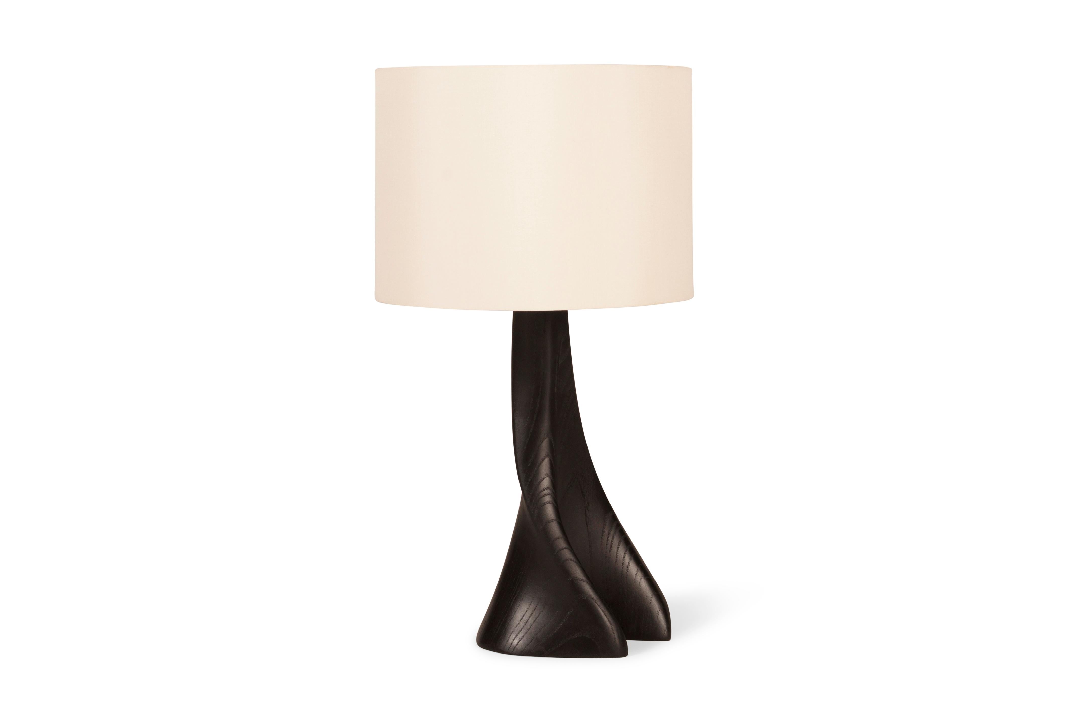 The Nile table lamp is a stunning addition to any luxury or modern home. With its elegant organic curve shape, it adds a touch of sophistication to any room. The lamp features an ivory silk shade and diffuser, providing a soft and warm glow.