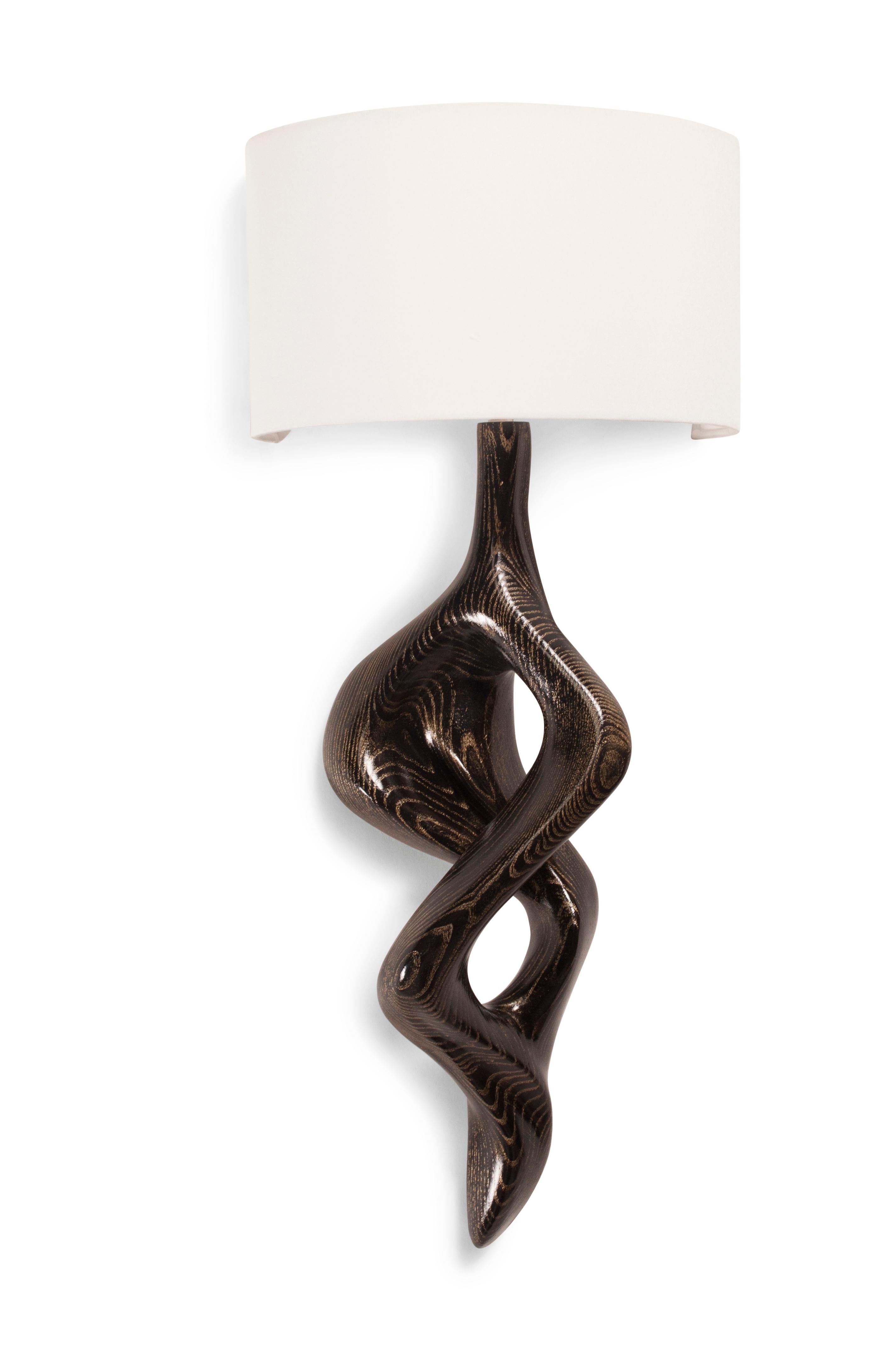 Nomi Sconce is carved from solid wood walnut with half a drum shape shade. Shade dimensions: 12