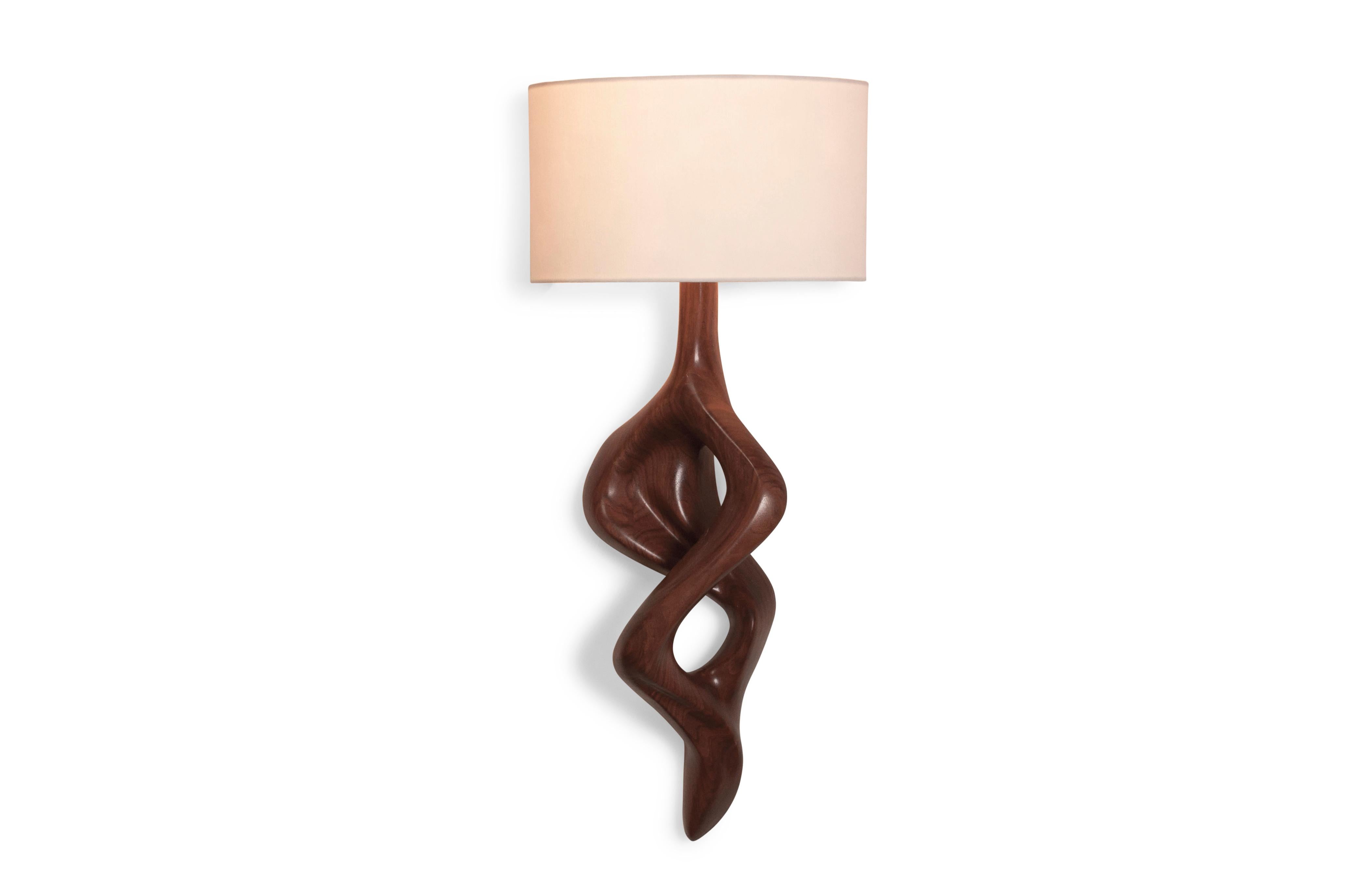 Nomi Sconce is carved from solid wood walnut with half a drum shape shade. Shade dimensions: 12