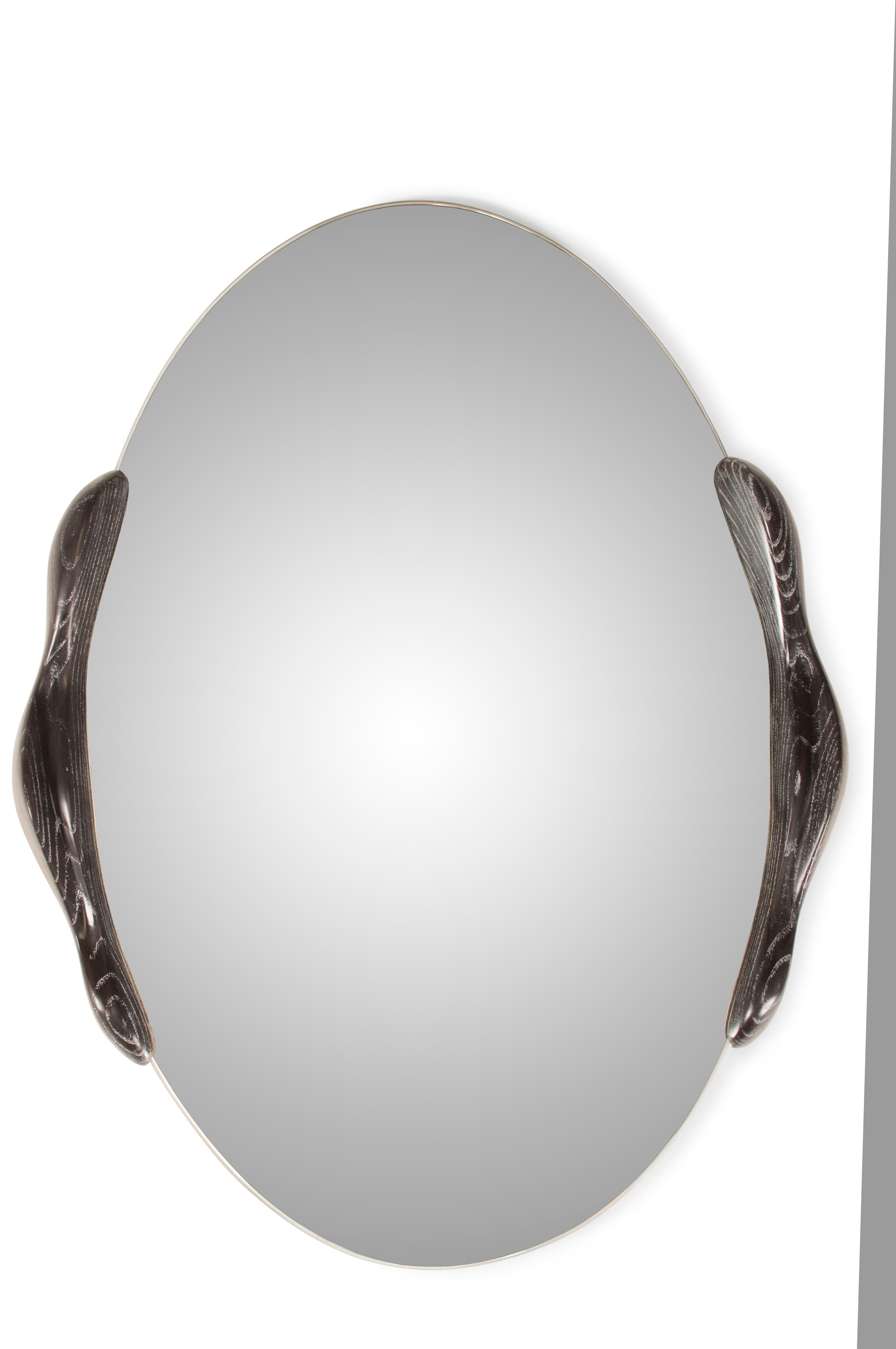 The ovate mirror is a stylish and modern addition to any contemporary home. Its oval shape adds a touch of elegance and sophistication to any space. The mirror is held in place by two small frames, which adds a unique and eye-catching design