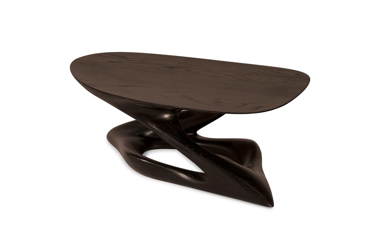 Plie coffee table is a stylish futuristic sculptural art table with a dynamic form designed and manufactured by Amorph. Plie is made out of solid ash wood and stained with dark walnut. By the nature, the ash wood grain’s look would be slightly