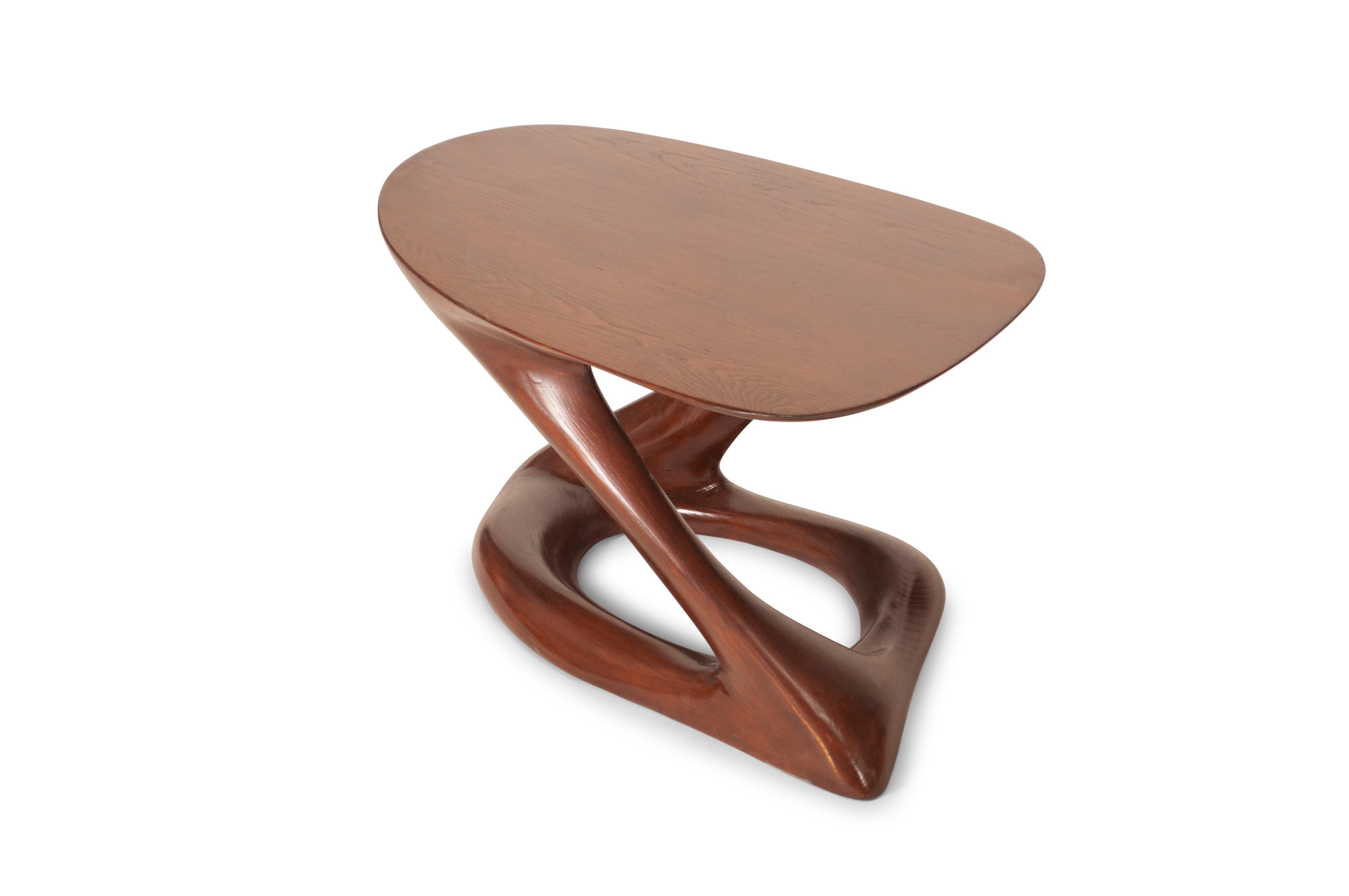 Der Plie Couchtisch ist ein stilvoller, futuristischer, skulpturaler Kunsttisch mit einer dynamischen Form, entworfen und hergestellt von Amorph. Plie ist aus massivem Eschenholz gefertigt und mit dunkler Walnuss gebeizt. Von Natur aus unterscheidet
